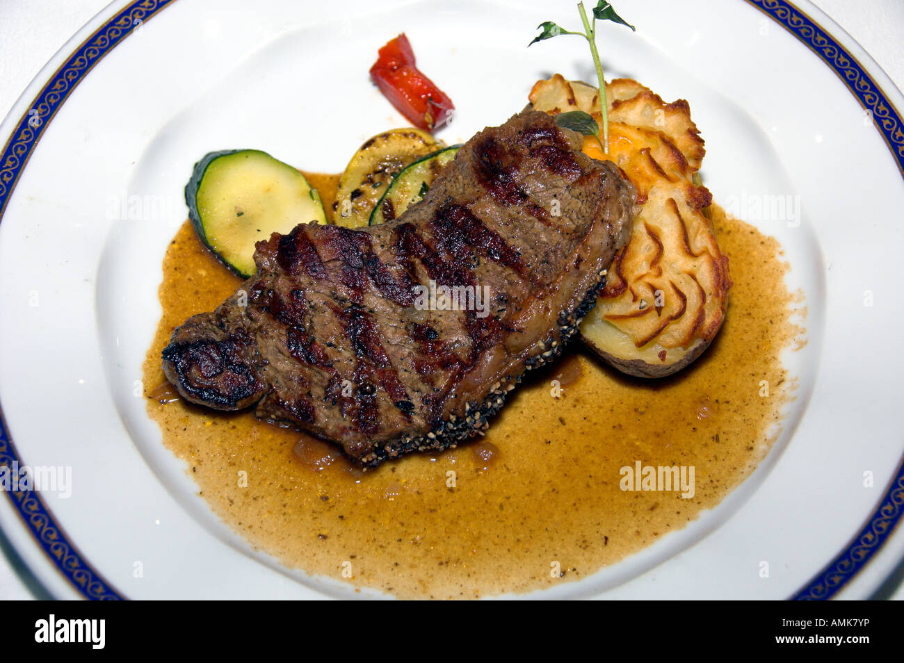 New York-Steak-Dinner mit zweimal gebackenen Kartoffeln und Auberginen auf dem Holland America Kreuzfahrtschiff Ryndam Stockfoto