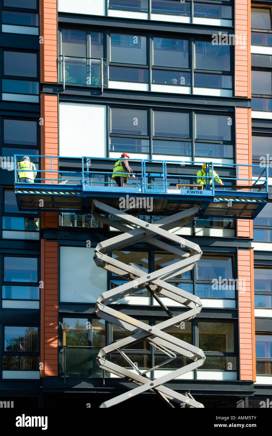 Männer arbeiten auf Wohnungen im ehemaligen Templetons Teppich Fabrik Glasgow Green Schottland Europe Stockfoto