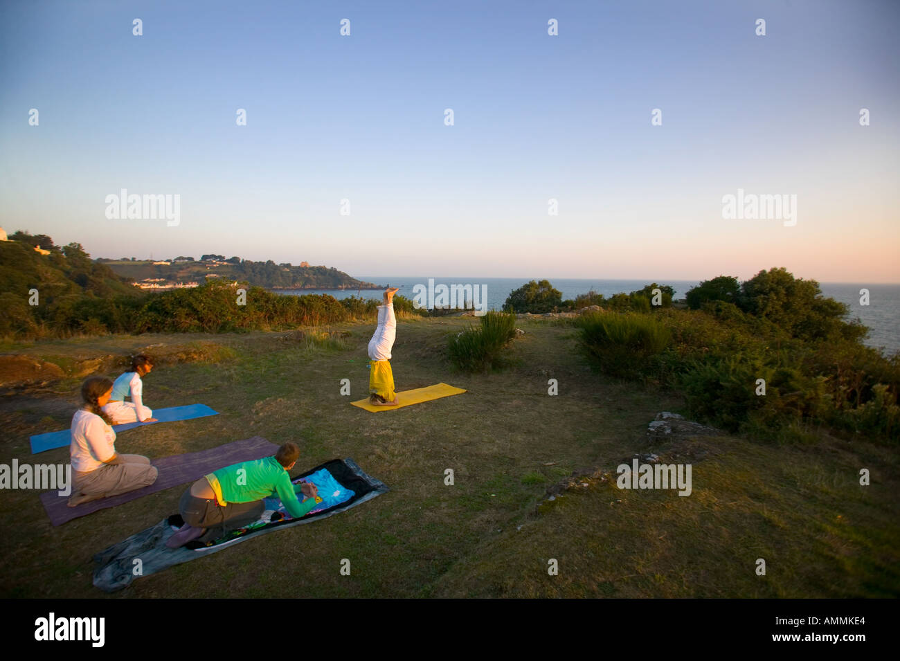 Üben Yoga am Dolmen du Couperon bei Sonnenaufgang Jersey Kanalinseln Stockfoto