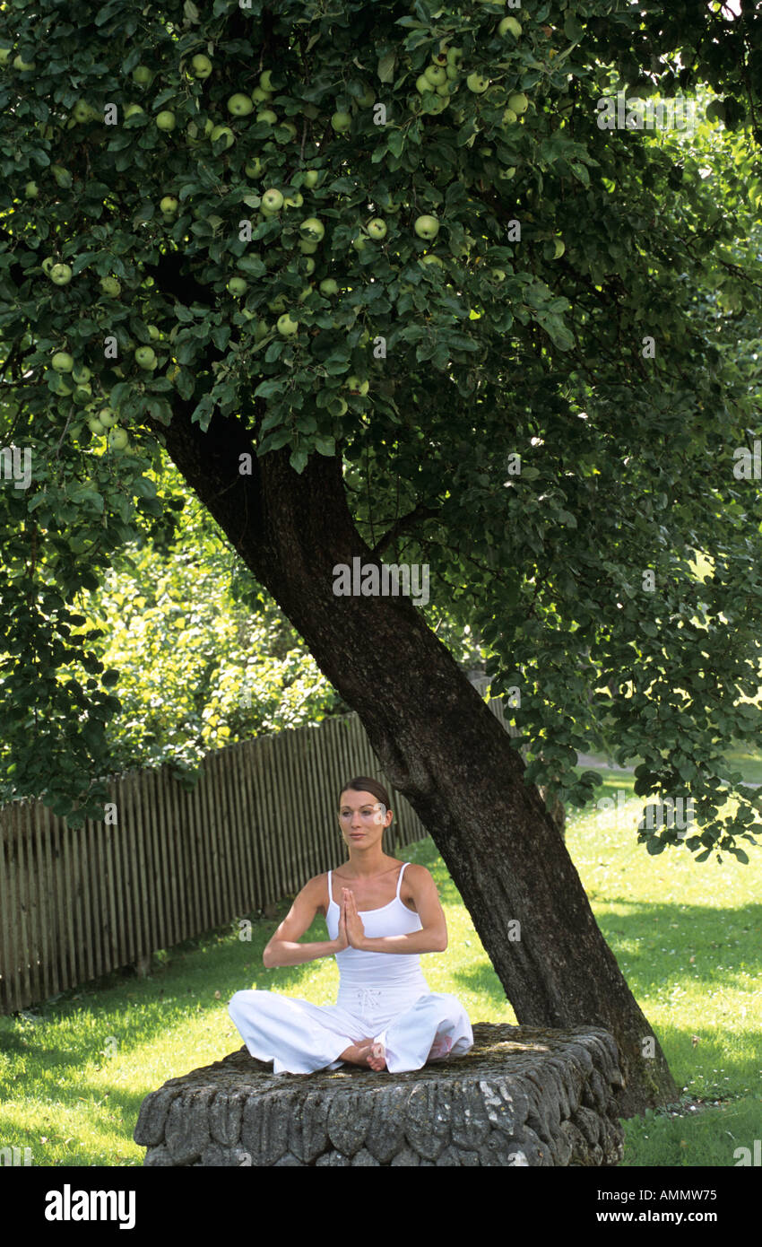 Junge Frau, die Meditation im Garten Stockfoto