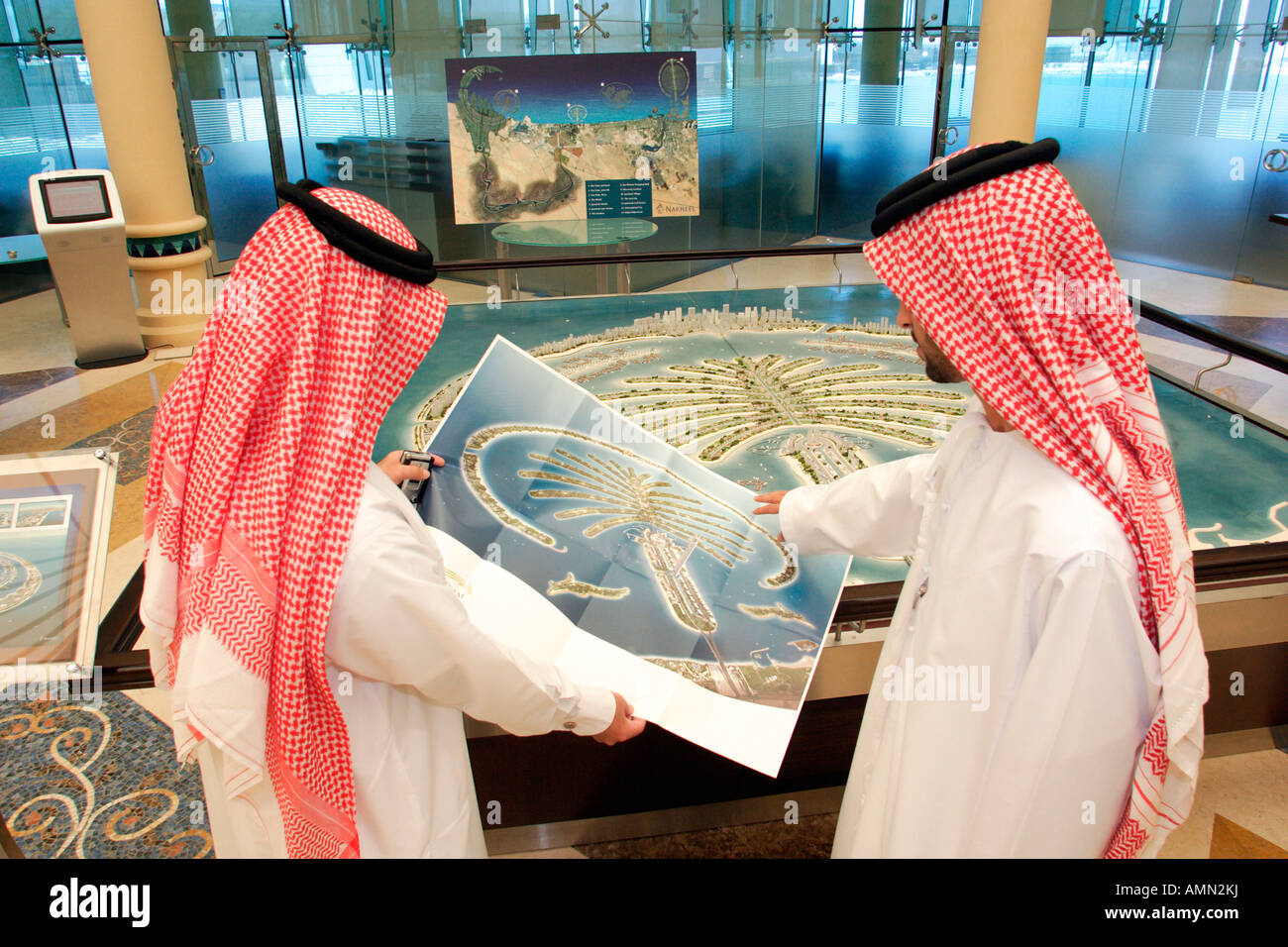 Zwei arabische Männer, die auf der Suche auf ein Modell der künstlichen Insel Palm Jebel Ali, Dubai, Vereinigte Arabische Emirate Stockfoto