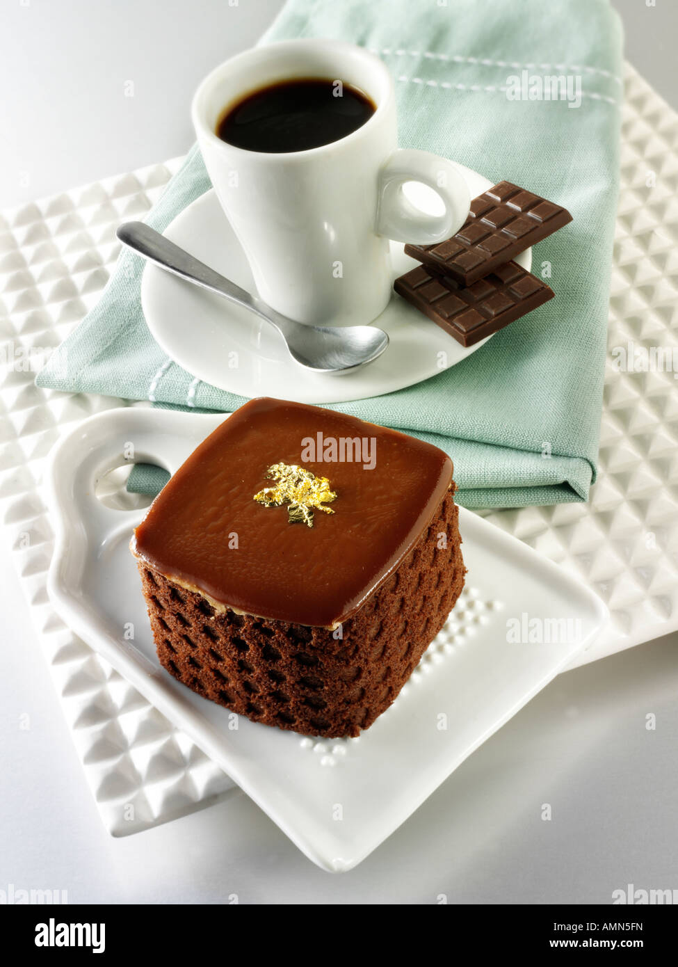 Eine handgemachte Patisserie Spezialität reichen verwöhnenden Schokoladenkuchen mit Kaffee in einem weißen Tisch Einstellung gefüllt Stockfoto