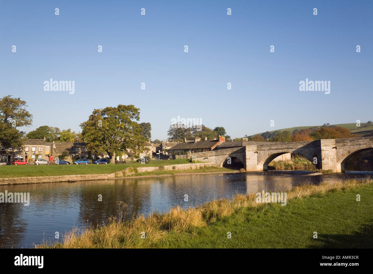 Fluß Wharfe und Stein gewölbten Brücke im malerischen Dorf in Yorkshire Dales National Park. Burnsall Wharfedale North Yorkshire England UK Stockfoto