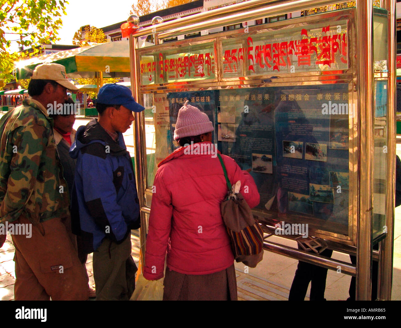 Neugierige Passanten Bilder ansehen und lesen Sie schockierende Berichte von Horror Verkehrsunfällen in einem Bürgersteig Display Shigatse Tibet Stockfoto