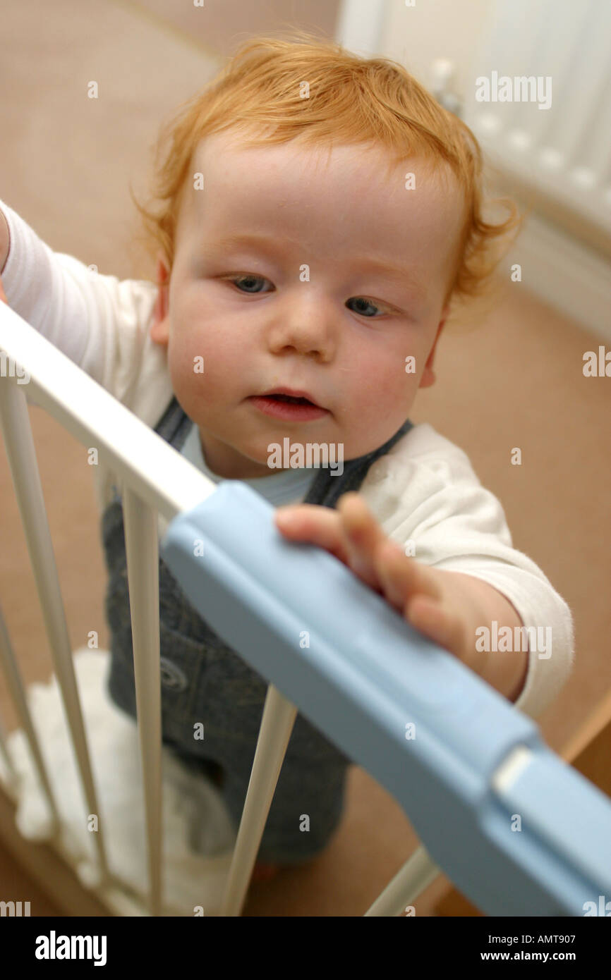 Ein Baby versucht ein Treppengitter Sicherheit zu öffnen Stockfoto