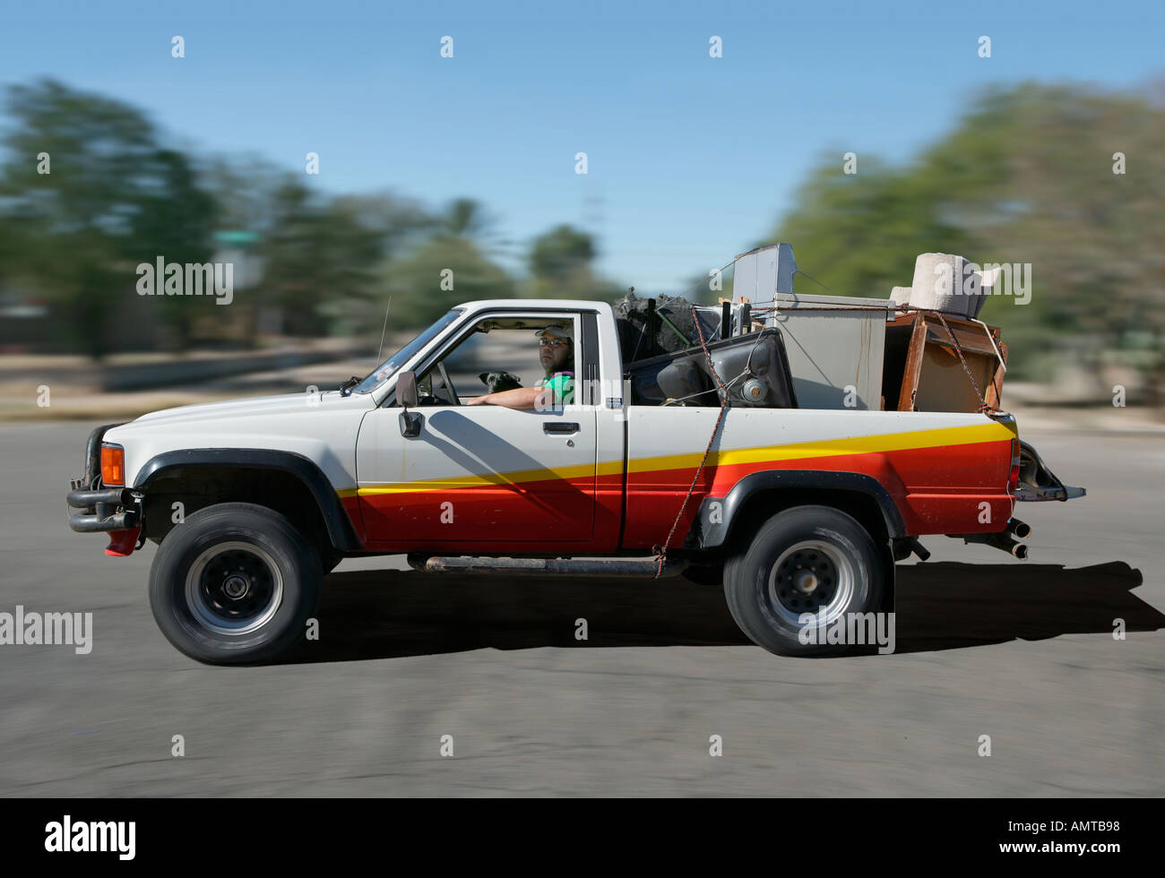 Ein Mann und sein Hund machen Sie einen Ausflug auf den Schrottplatz mit einer LKW-Ladung Müll Stockfoto