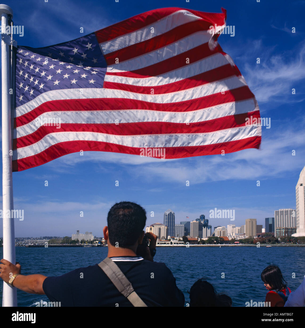 Menschen auf der Fähre Blick auf die Skyline der Innenstadt mit riesigen USA-Flagge im Vordergrund San Diego Kalifornien U S A Stockfoto