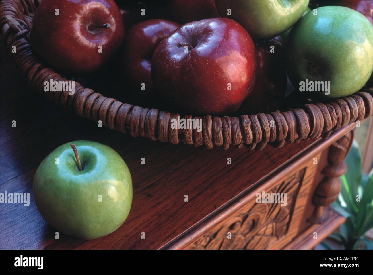 Äpfel in einem Korb auf einem Buffet in der Nähe eines Fensters mit natürlichem Licht Stockfoto