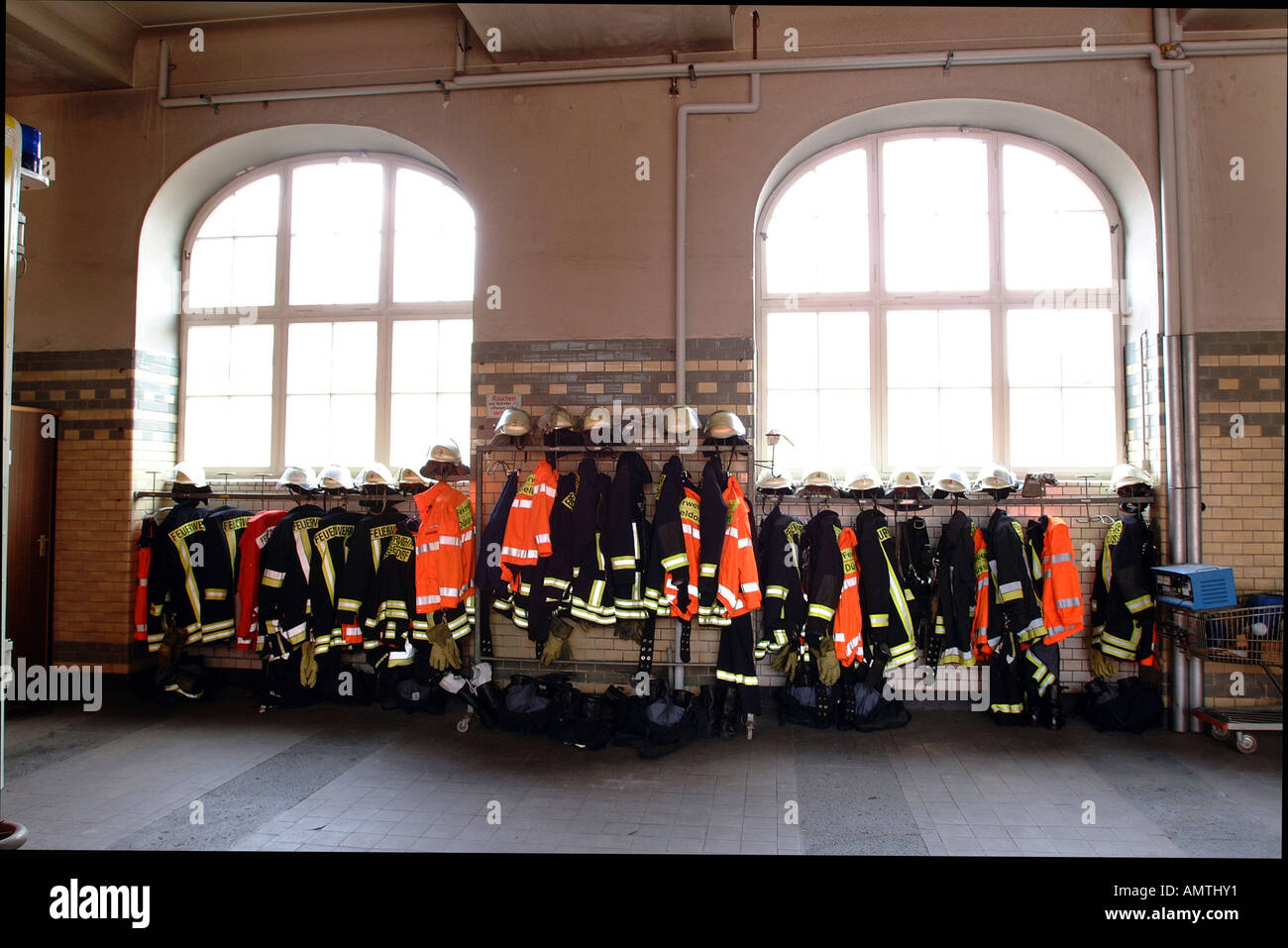 Feuerwehr-Outfits vor Fenstern Stockfoto