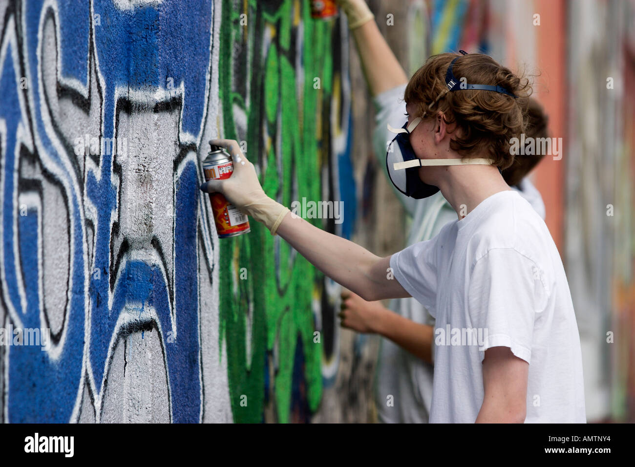 Graffiti-Sprayer mit Atemschutz bei der Arbeit Stockfoto