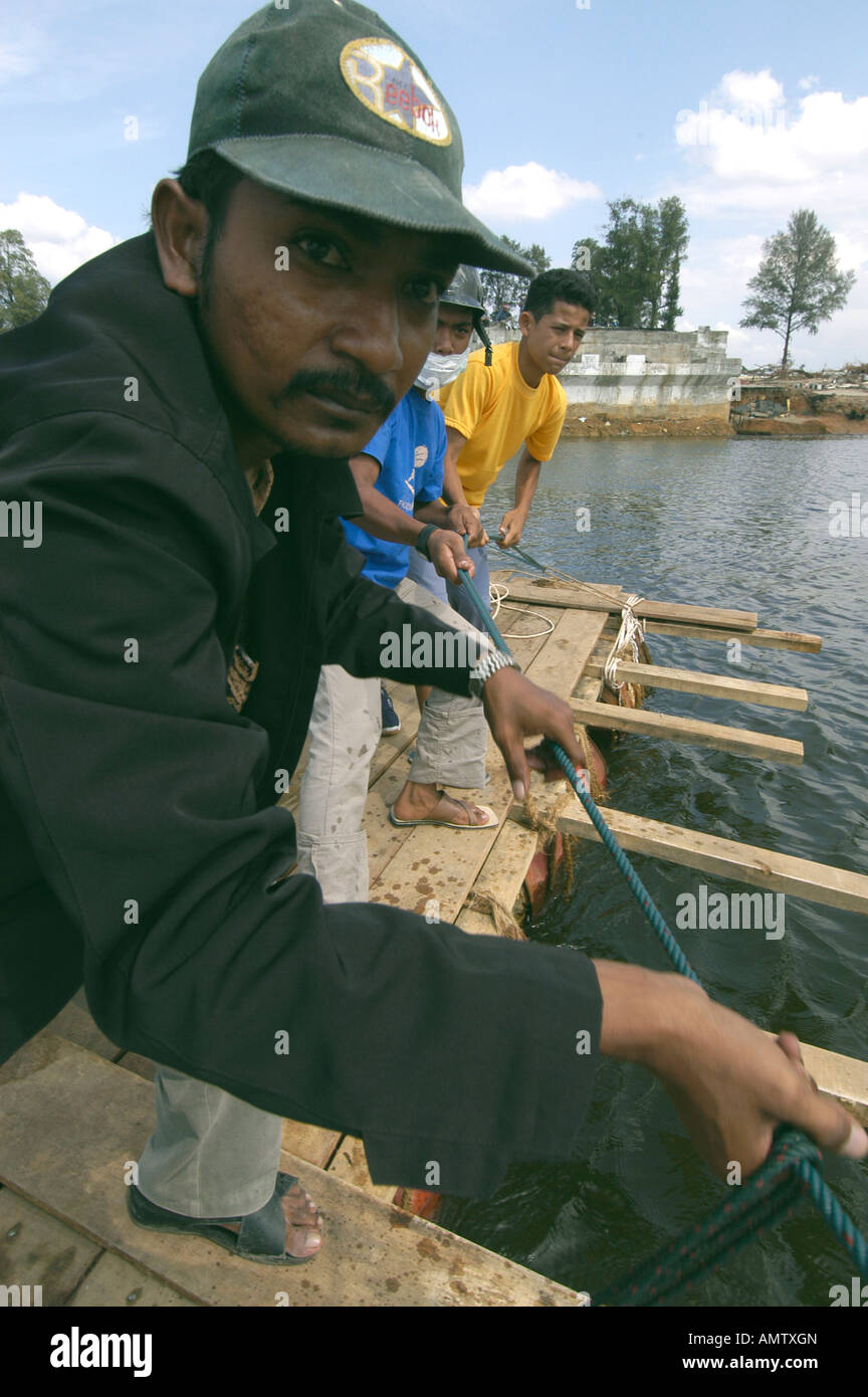 Eine Gruppe von Männer ziehen ein Floß über den Fluss in Indonesien Lhok Nga auf Samstag, 8. Januar 2005 endet die Küstenstraße an der Fluss-cros Stockfoto