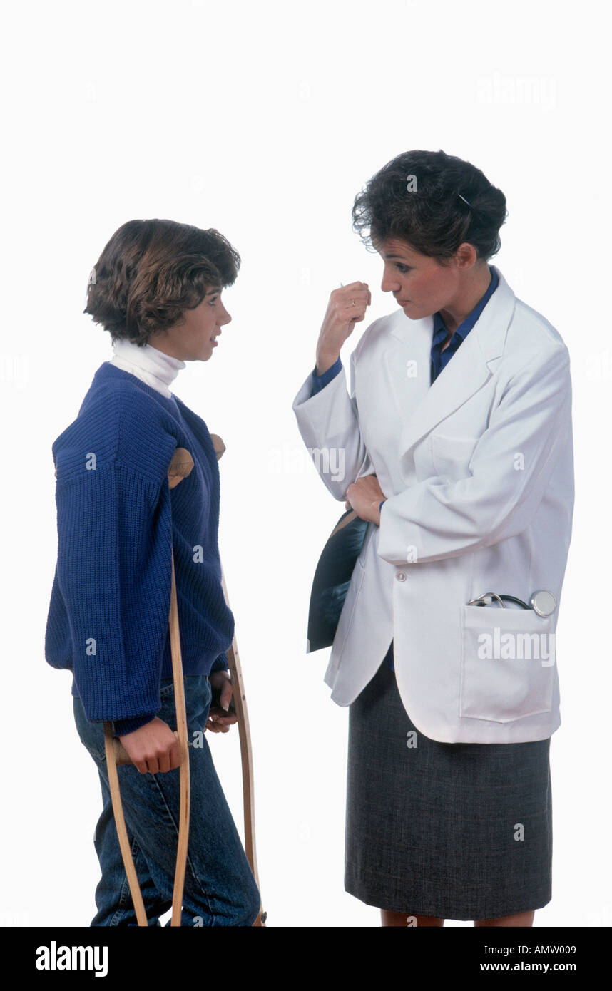 Arzt im Gespräch mit weiblicher Jugendlicher Patient auf Krücken Stockfoto