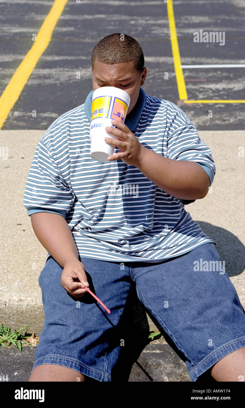 Übergewichtige Teenager männlich trinkt eine kalorienreiche Limonade Stockfoto