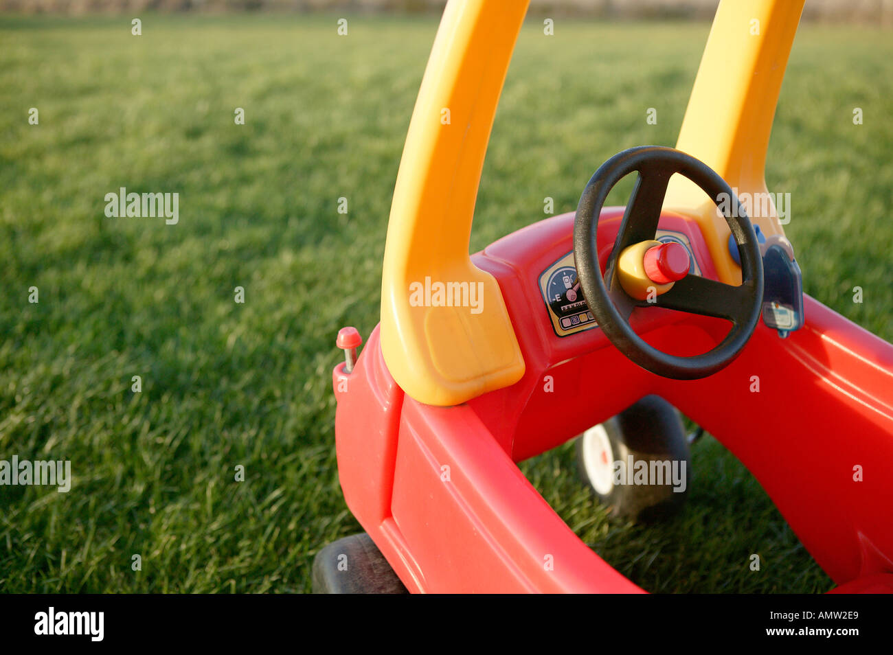 rote und gelbe Kinder Spielzeug Auto zeigen Cockpit mit Lenkrad und große  Rasenfläche Garten bietet Exemplar fahren Stockfotografie - Alamy