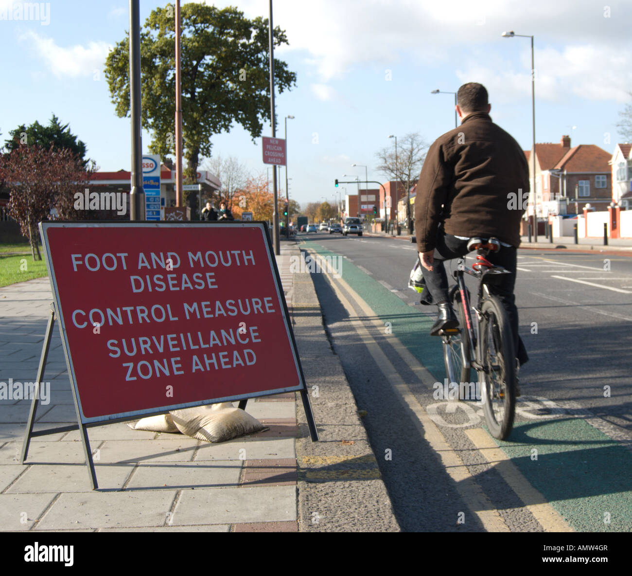 Männliche Radfahrer geht eine offizielle Schild markiert den Rand eine Überwachungszone 2007 für Maul- und Klauenseuche in england Stockfoto