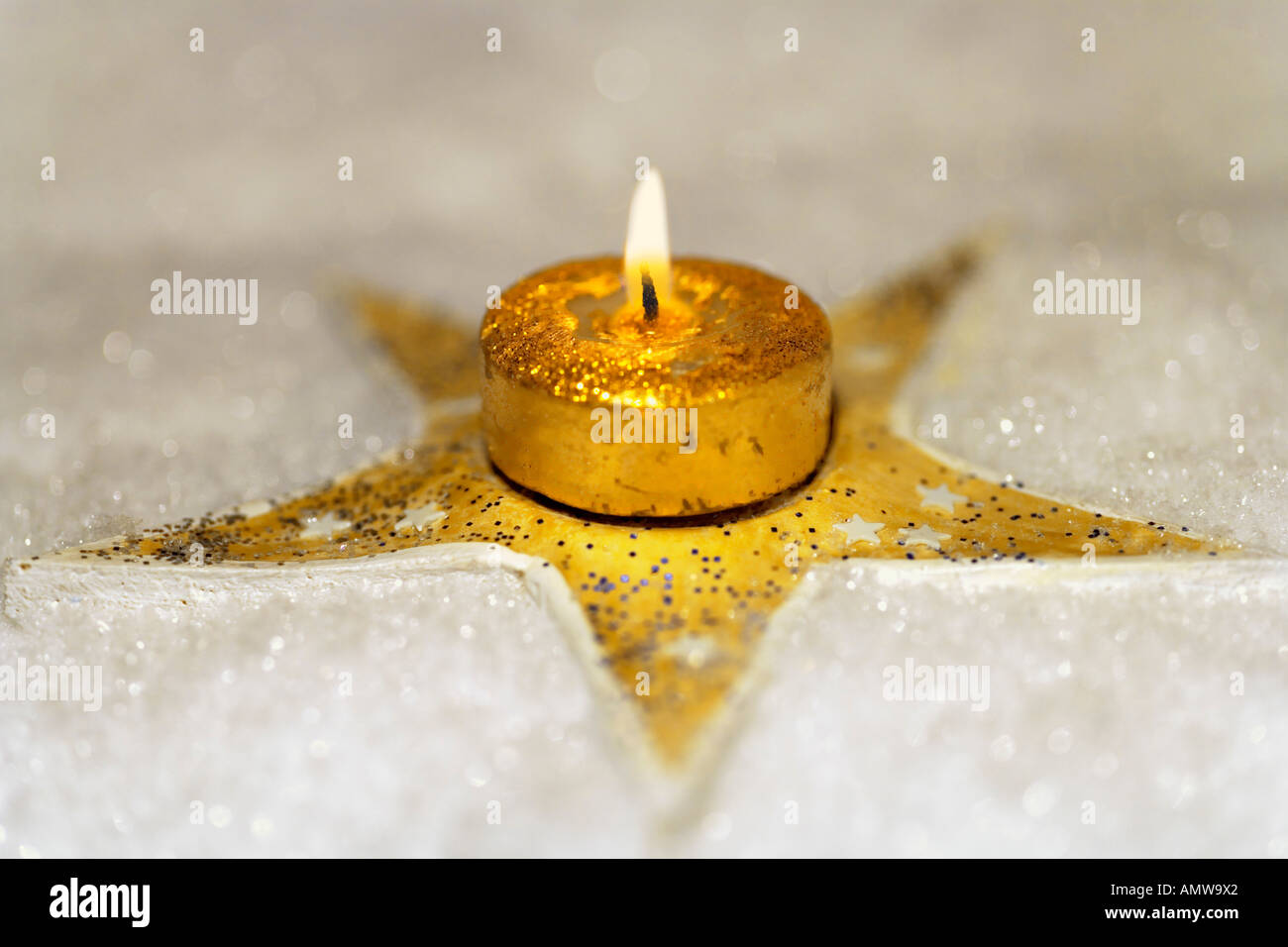 Goldener Stern im Schnee mit goldenen Kerze Stockfoto