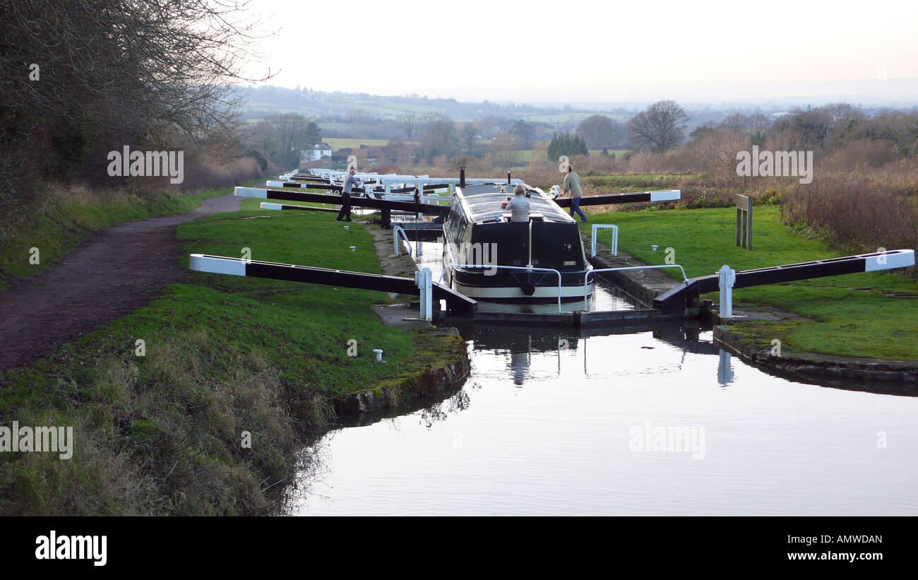 ein Narrowboat durchlaufen eine Sperre auf dem Kennet und Avon Kanal dabei, über eine große Schlösser absteigen. Stockfoto