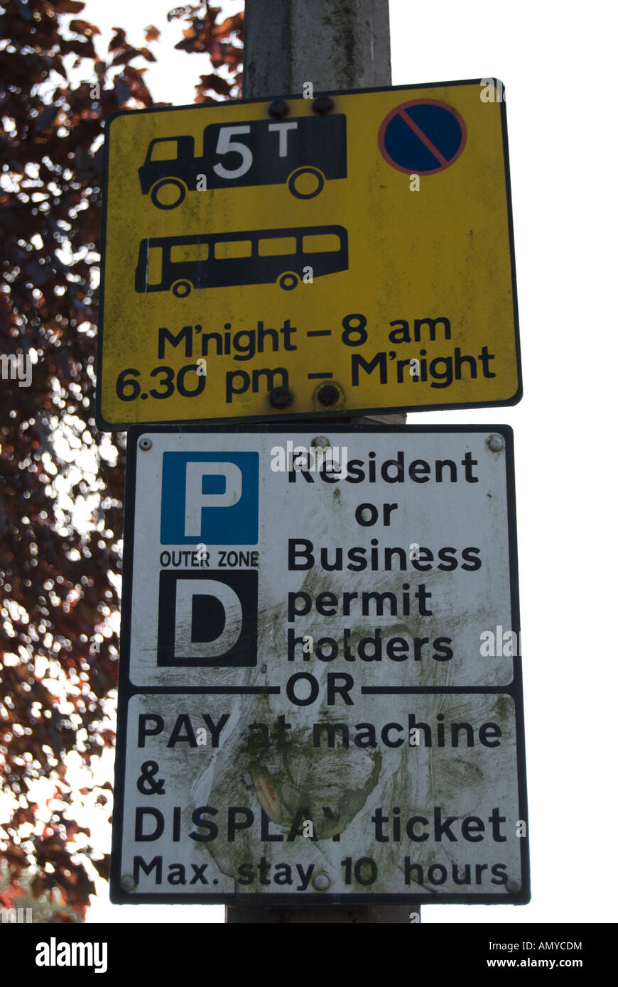 zwei schmutzige Verkehrszeichen, befestigt an einem Laternenmast in Twickenham, Bezahlung und Display Parkplätze und Parkplätze Einschränkung anzukündigen Stockfoto