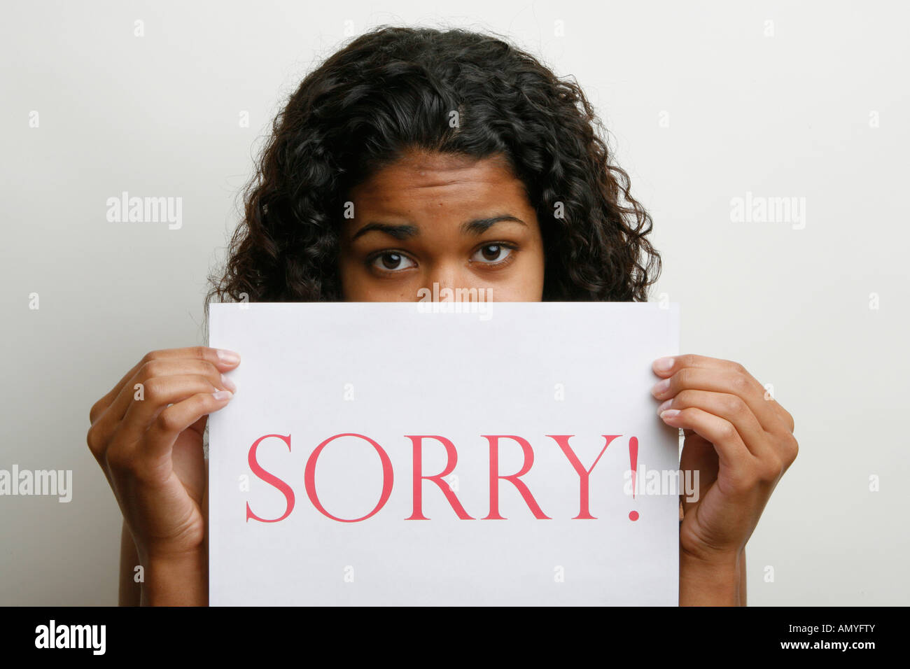 Porträt einer jungen Frau mit Karte mit einer Botschaft - Sorry! HERR-12-17/18-07 Stockfoto