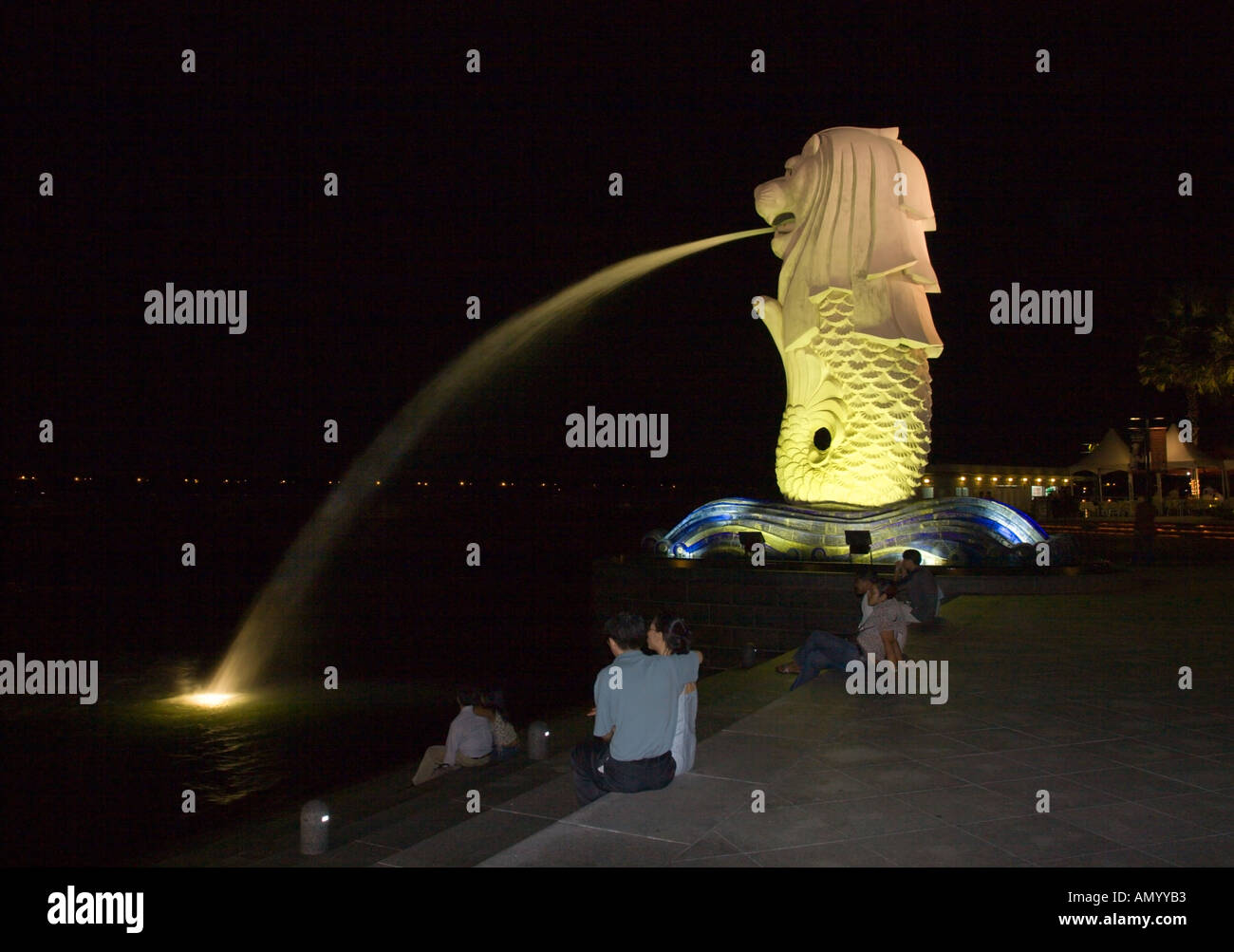 Romantische Kulisse der Paare sitzen auf den Stufen am Merlion Brunnen bei Nacht Singapore Stockfoto