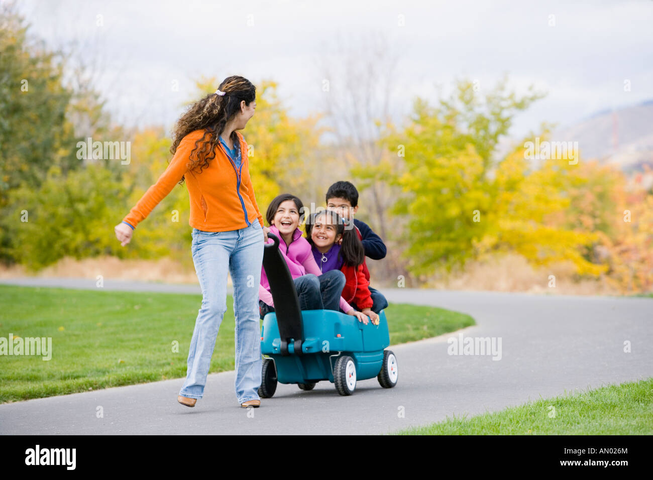 Hispanische Mutter ziehen Kinder in Wagen Stockfoto