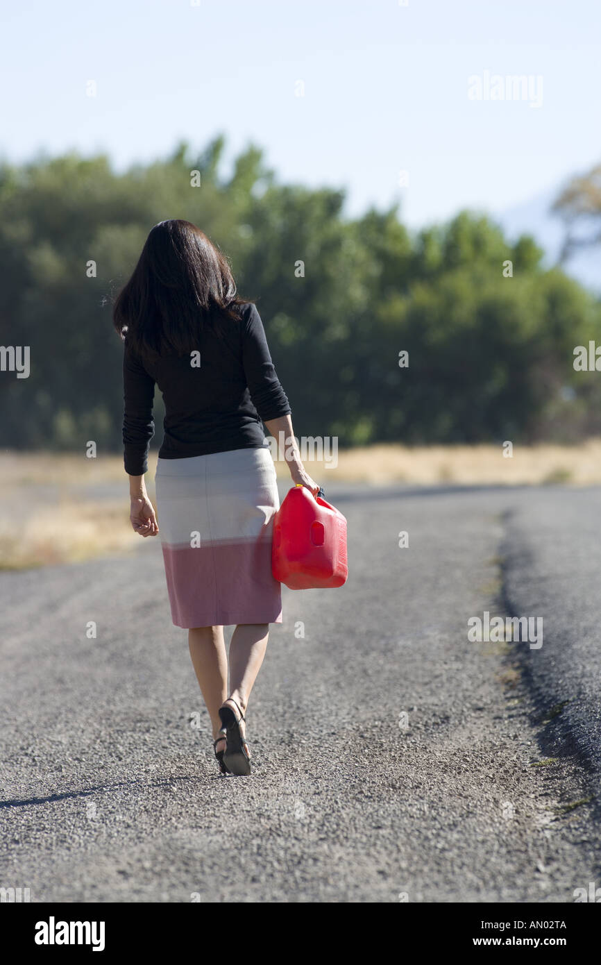 Rückansicht einer Frau zu Fuß mit einem Gas kann Stockfoto