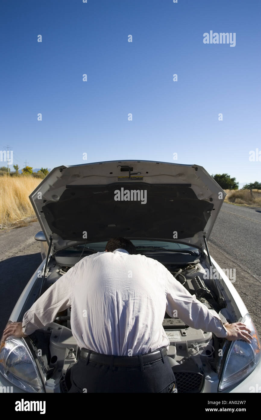 Rückansicht eines Geschäftsmannes Überprüfung seiner Automotor Stockfoto