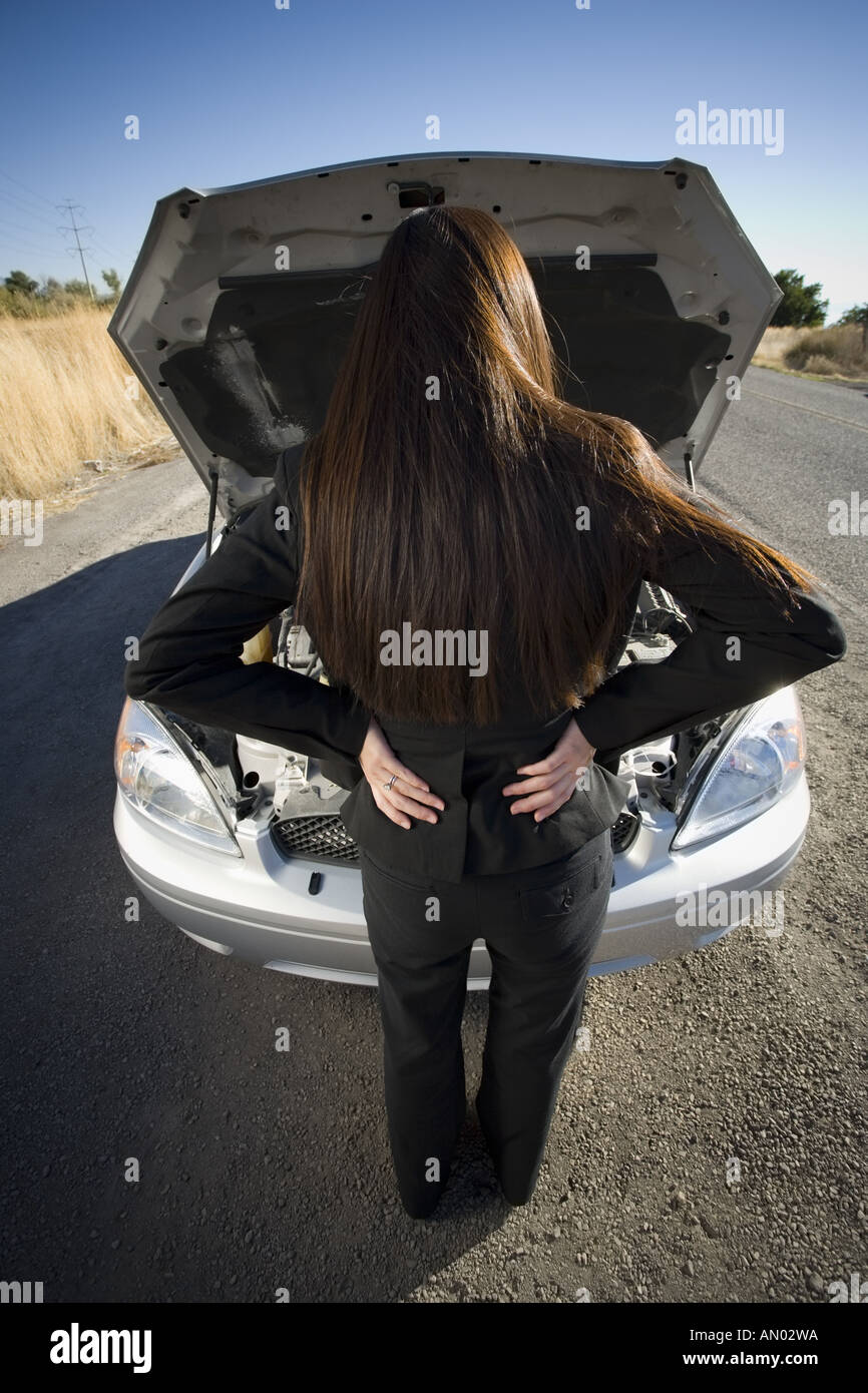 Rückansicht einer Frau überprüfen ihr Automotor Stockfoto