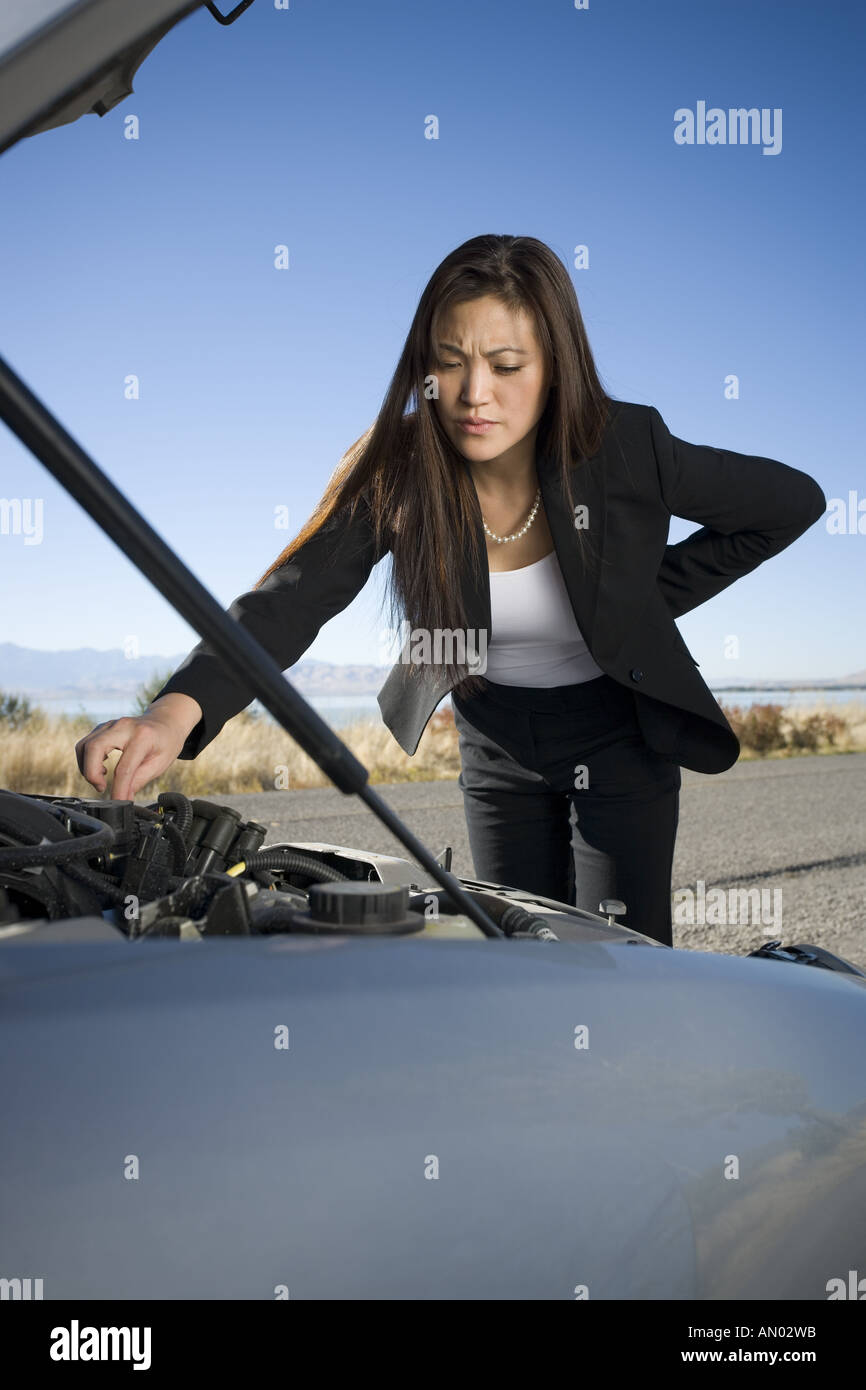 Frau reparieren überprüfen ihr Automotor Stockfoto