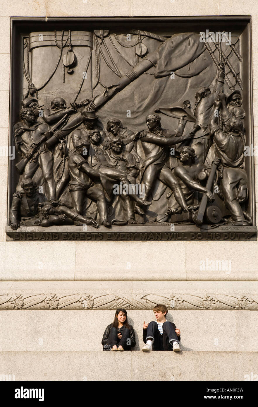 UK London Trafalgar Square paar saß unten Bronze Kampfszene auf Nelsons Säule Stockfoto