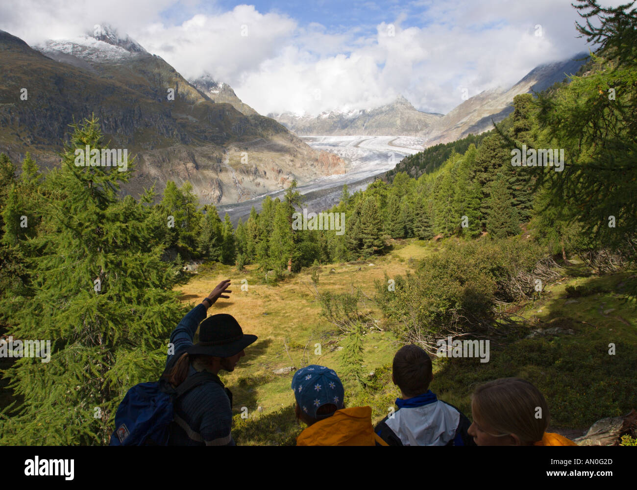 Ein Leitfaden betont Funktionen zu besuchen Schülerinnen und Schüler des Grossen Aletschgletschers über Tal mit Bäumen Wallis Schweiz Stockfoto