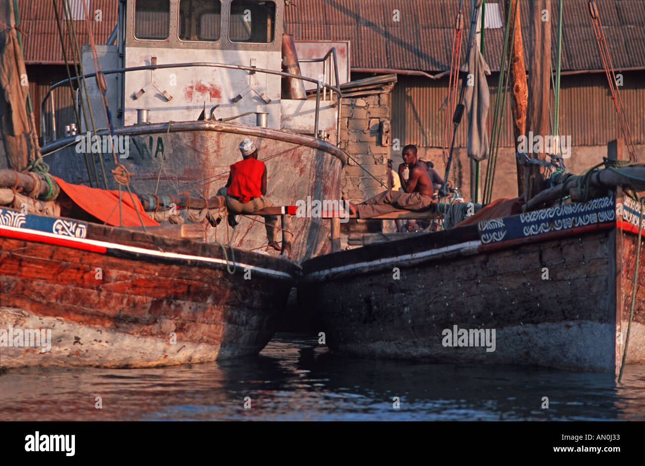 Fischer sitzt auf ihr Boot in den späten Nachmittag Stone Town Hafen Unguja Sansibar Tansania Stockfoto