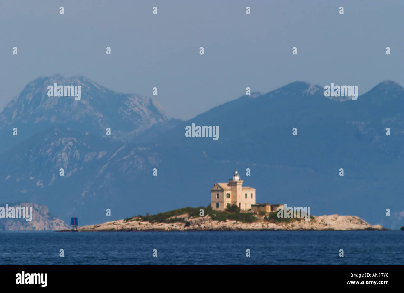 Ein Leuchtturm Leuchtturm auf einer Insel außerhalb des Dorfes, Blue Mountains im Hintergrund. Soft-Fokus. Orebic Stadt, Ferienort an der Südküste der Halbinsel Peljesac. Orebic-Stadt. Halbinsel Peljesac. Dalmatien, Kroatien, Europa. Stockfoto