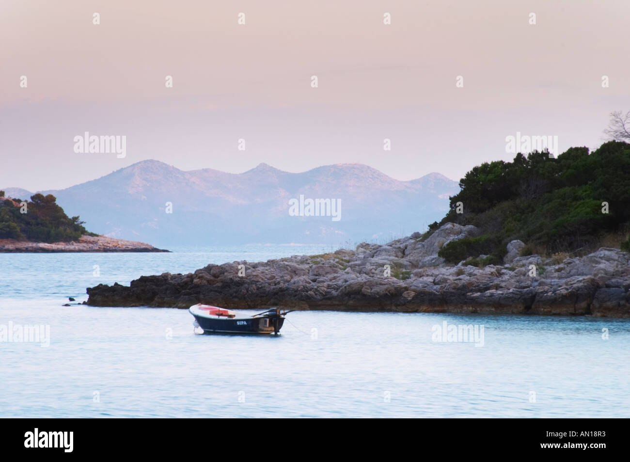 Blick über das Meer, Inseln und Berge mit einen kleinen motor Sportboot ankern vor der Insel Korcula bei Sonnenuntergang. Prizba Dorf. Insel Korcula. Prizba, Riva Apartments, Danny Franulovic. Insel Korcula. Dalmatien, Kroatien, Europa. Stockfoto