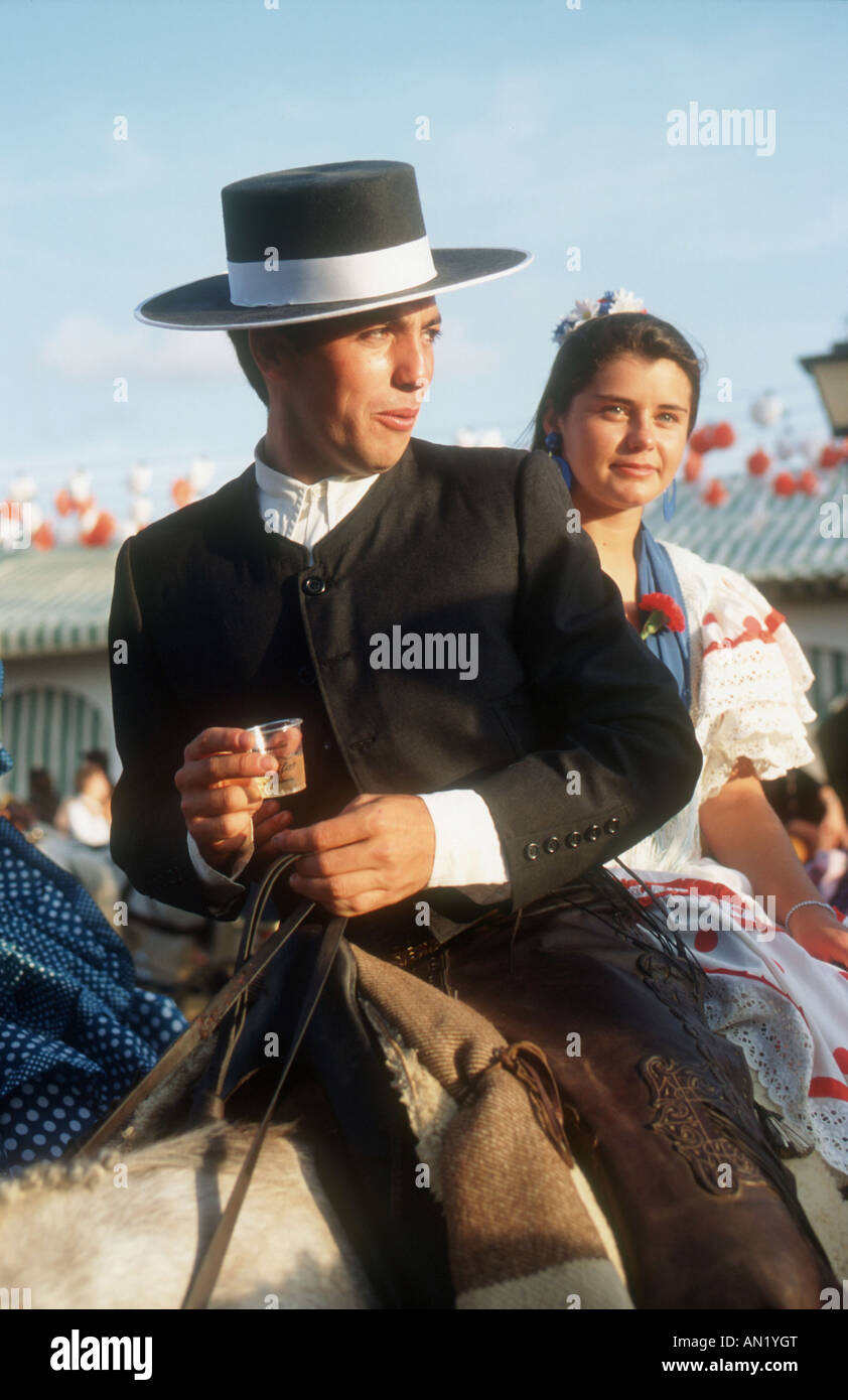 Paar, Reiten auf dem Pferd auf der Frühjahrsmesse Sevilla mit dem Mann trinken Sherry. Stockfoto
