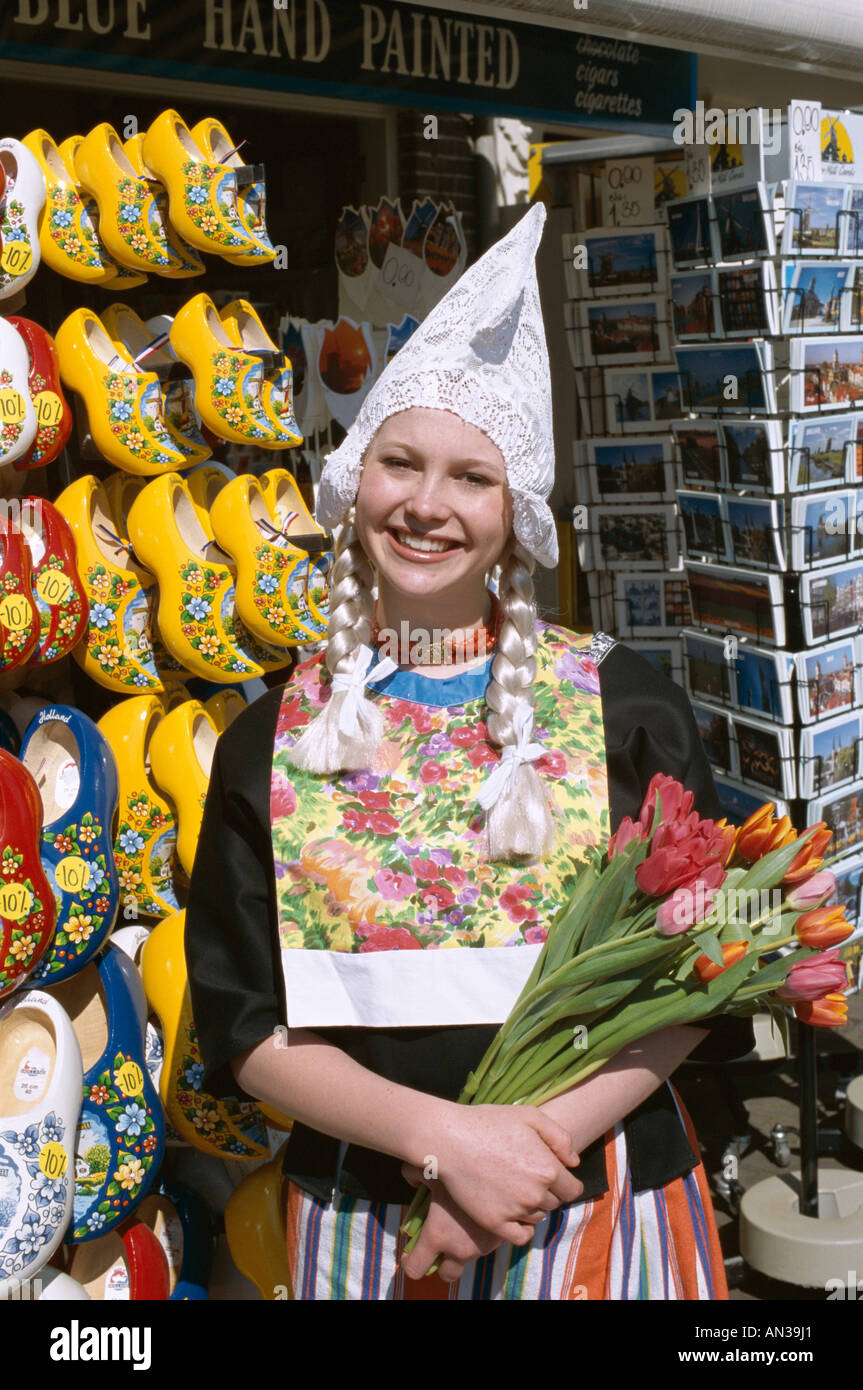 Souvenir-Shop Verkauf Clogs & Postkarten / Mädchen gekleidet in niederländischen Kostüm halten Tulpen, Amsterdam, Holland (Niederlande) Stockfoto