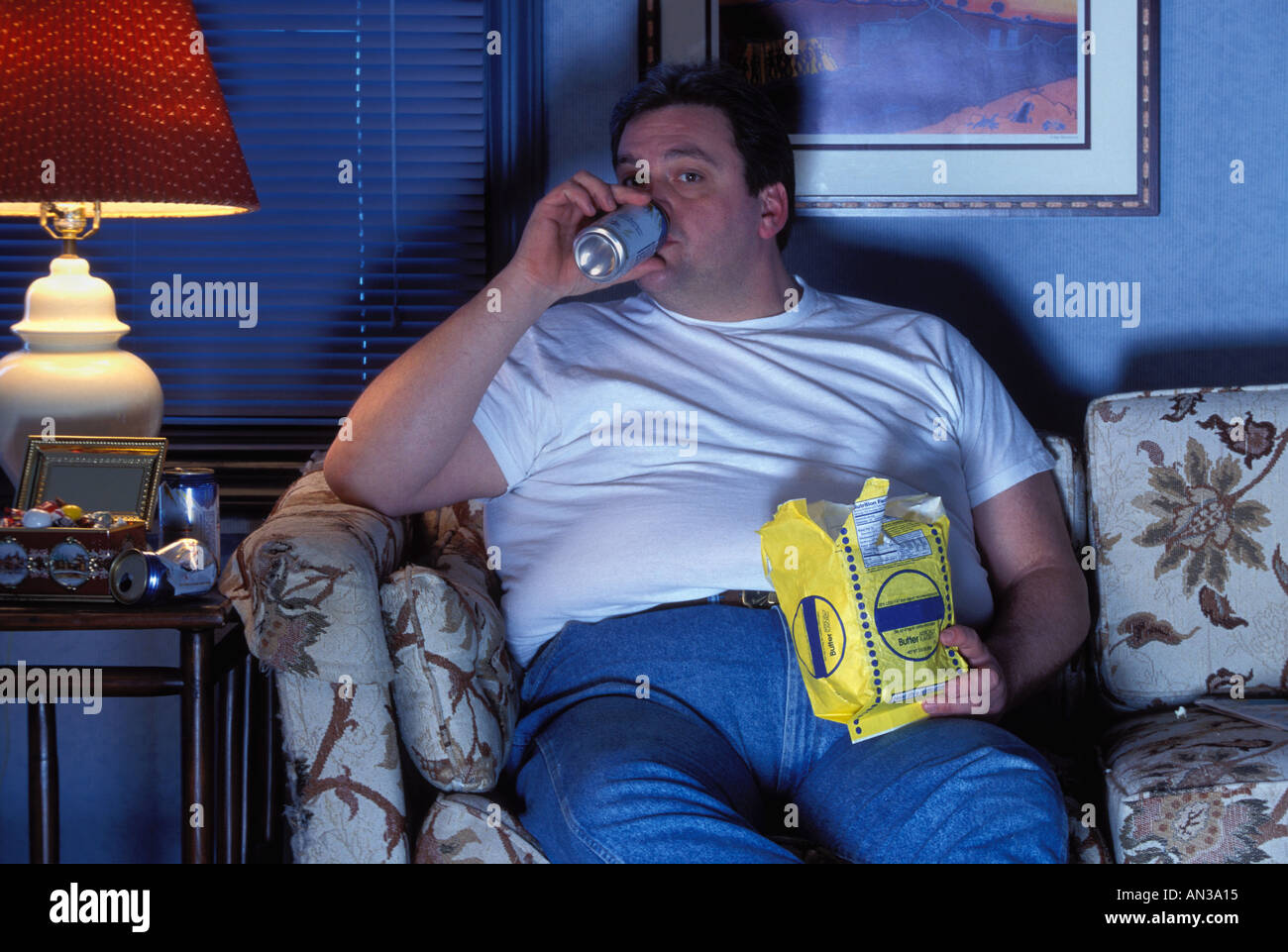 Übergewicht Couch potato Mann Fernsehen Bier trinken und essen Popcorn Stockfoto