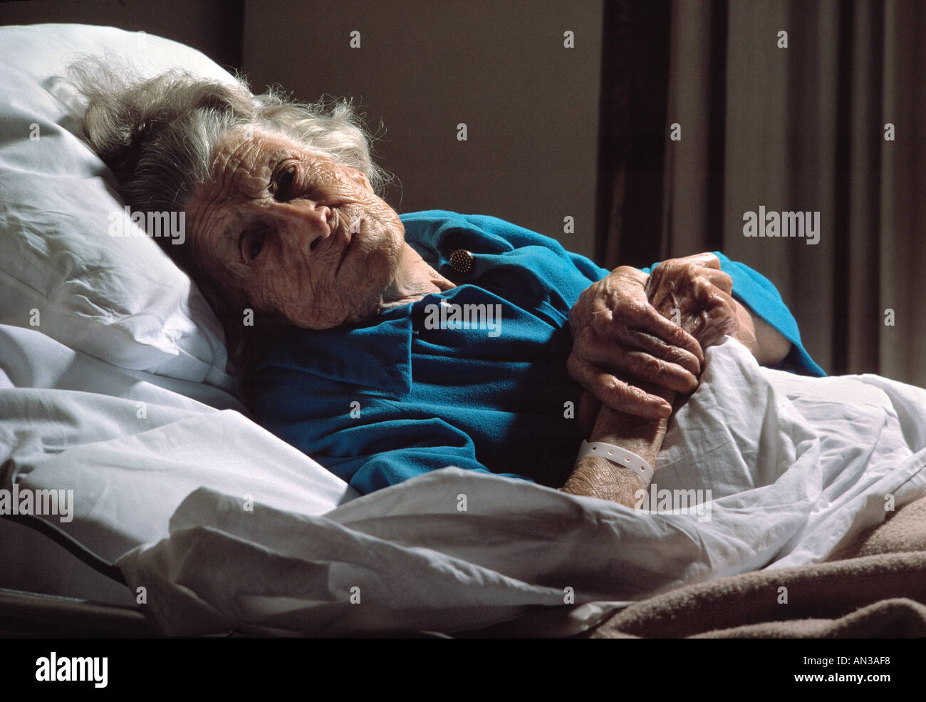 Kaukasische Seniorin im Bett liegend in Pflegeheim Stockfoto