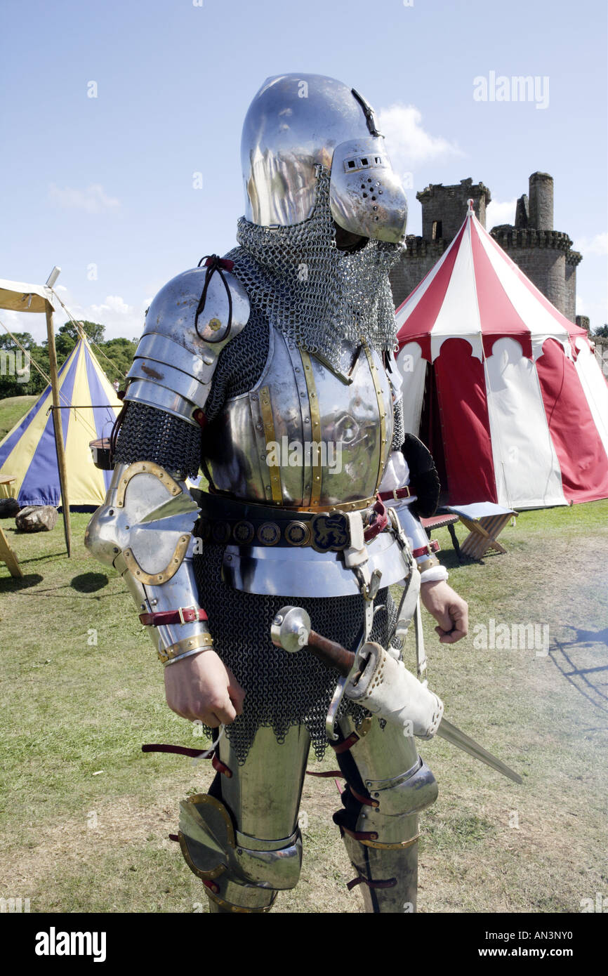 Mittelalterliche Ritter in Rüstung mit Caerlaverock Castle hinter Stockfoto