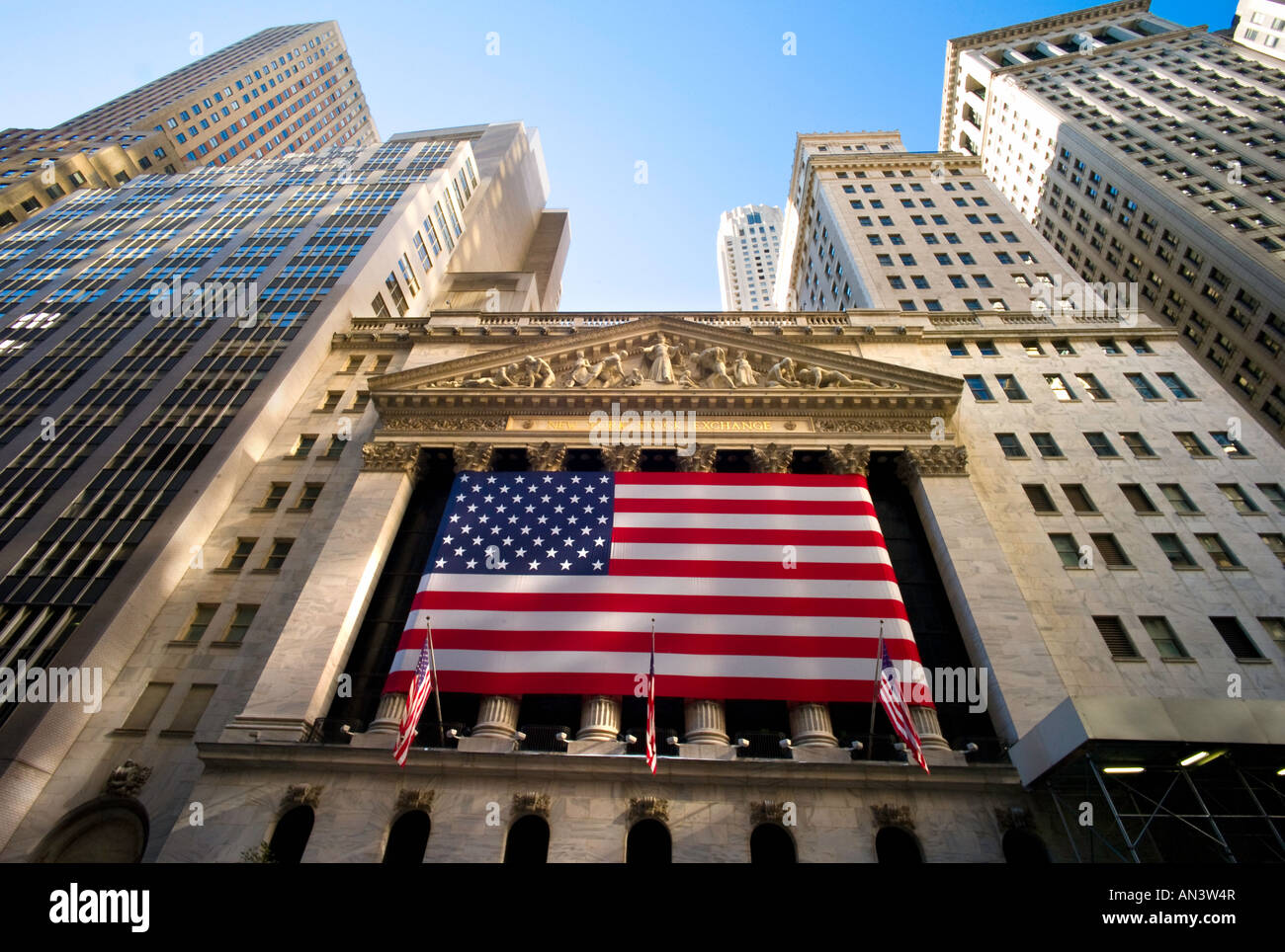 NEW YORK CITY NEW YORK New York Stock Exchange Wall Street mit amerikanischen Fahnen in Front und Wolkenkratzer oben Stockfoto