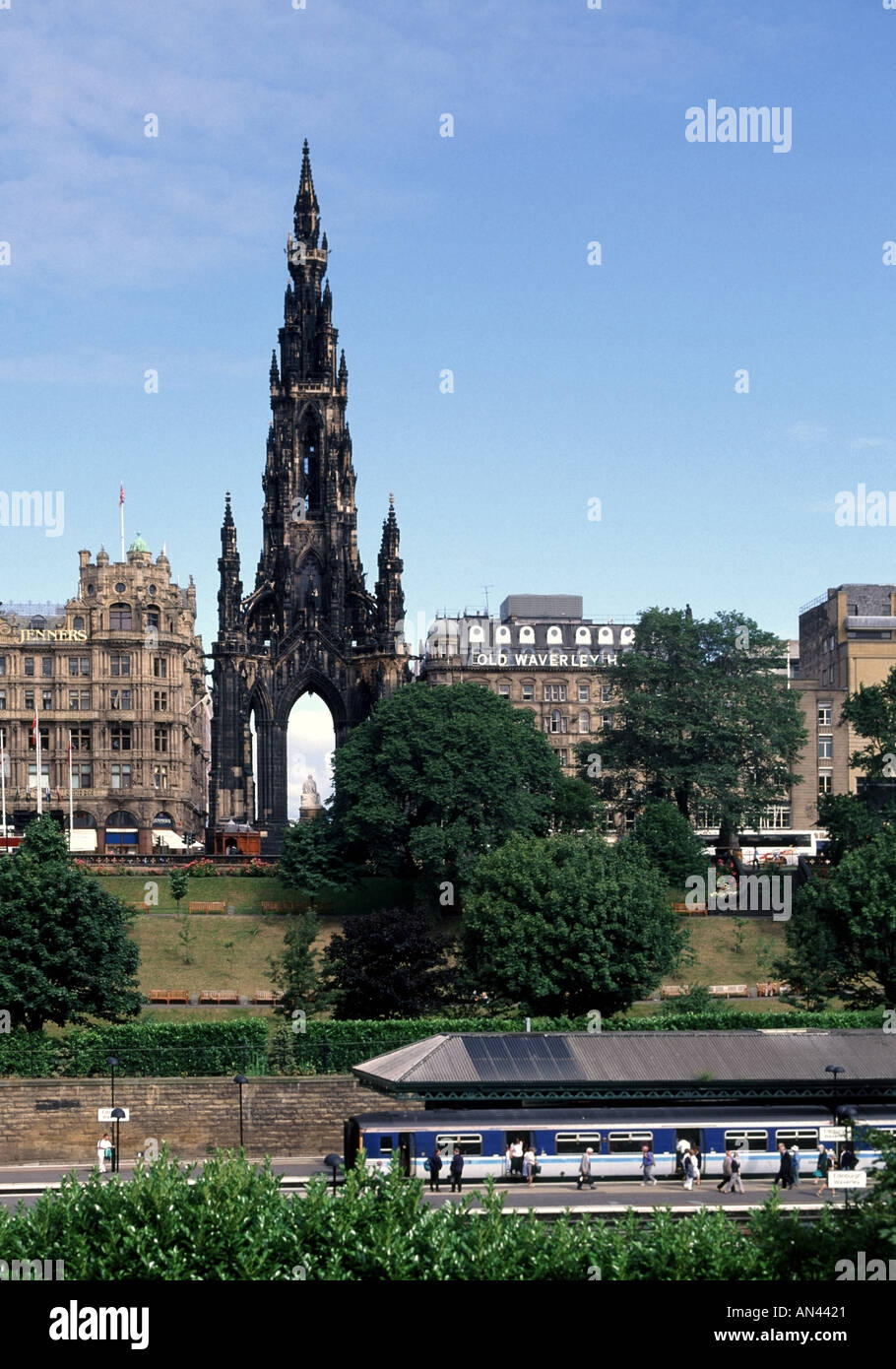 Bahnreisende der Stadt Edinburgh am Bahnhof Waverley mit historischem Denkmal für Sir Walter Scott Beyond mit Geschäft und Hotel in Schottland, Großbritannien Stockfoto