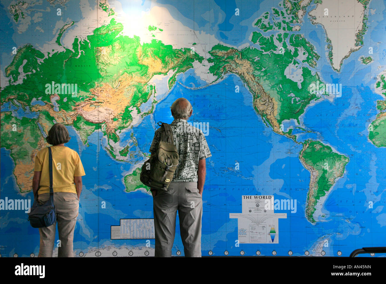 Reisende betrachten große Wandkarte der Welt in Flughafen Auckland Neuseeland Stockfoto
