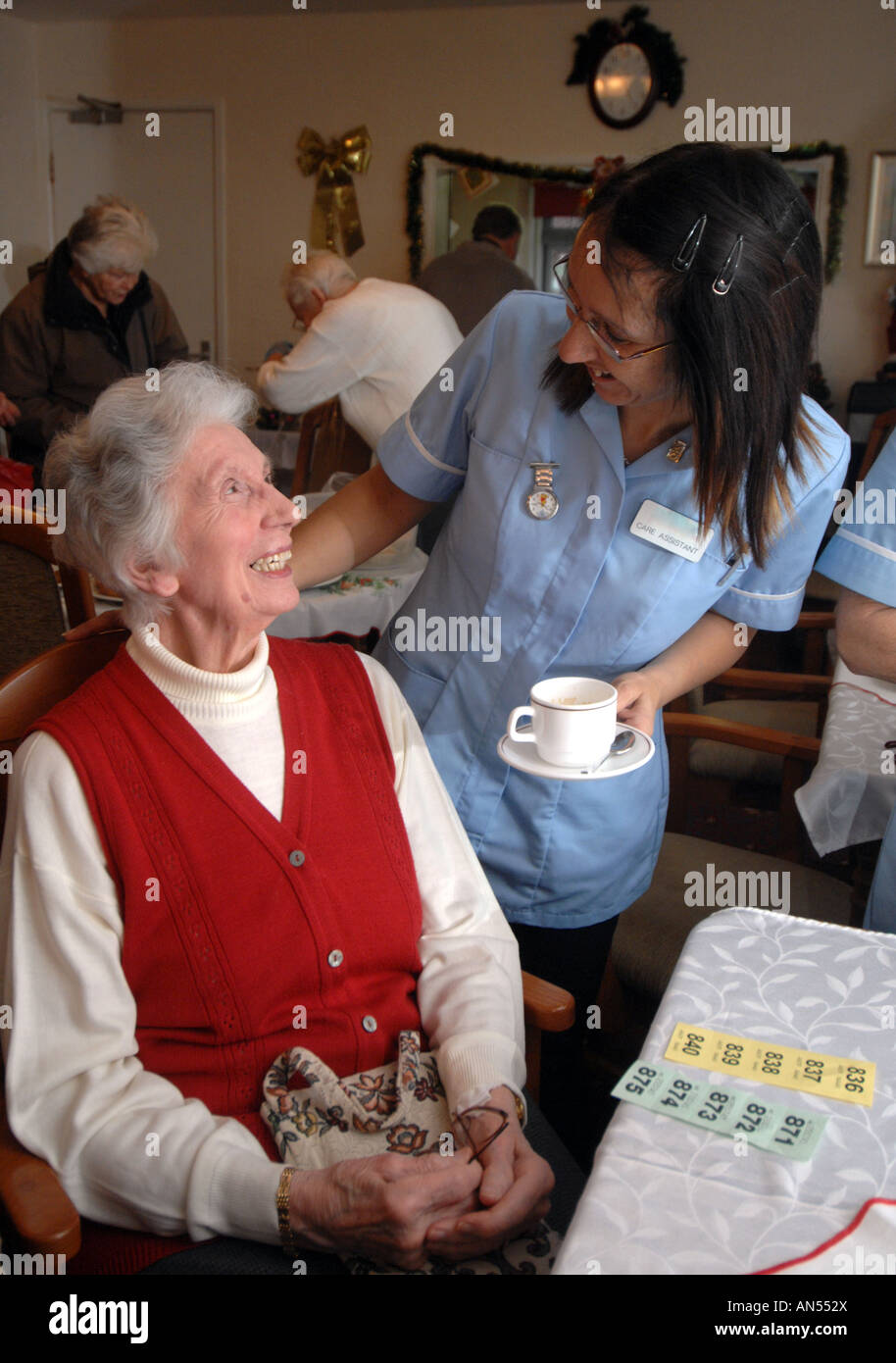 Eine Frau bekommt eine Tasse Tee in einem Pflegeheim, England Stockfoto