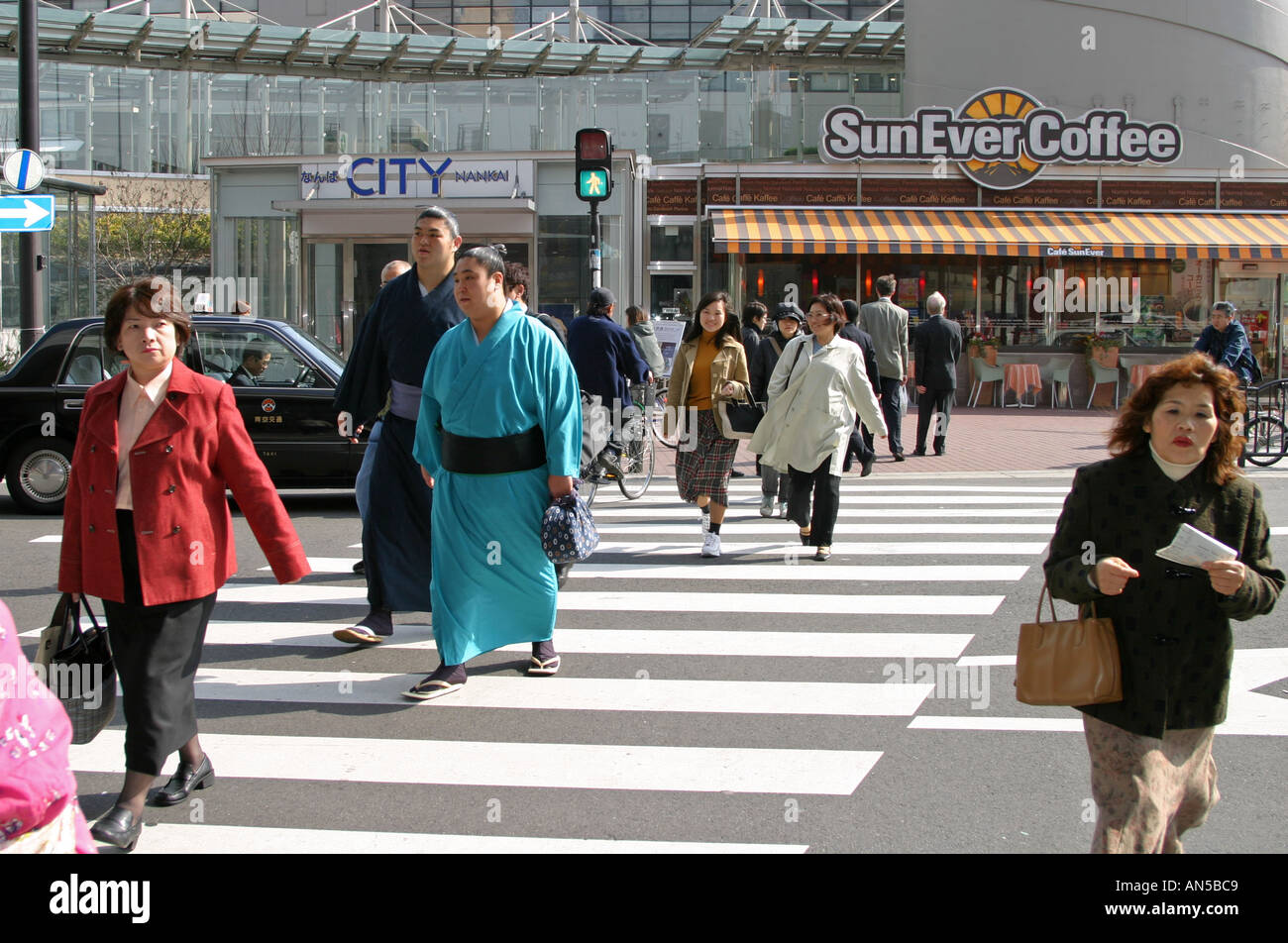 Zwei Sumo-Ringer überqueren Sie die Straße auf einem Zebrastreifen Annäherung an die Präfektur Osaka Stadion auf dem Weg zu den Frühling sumo Stockfoto