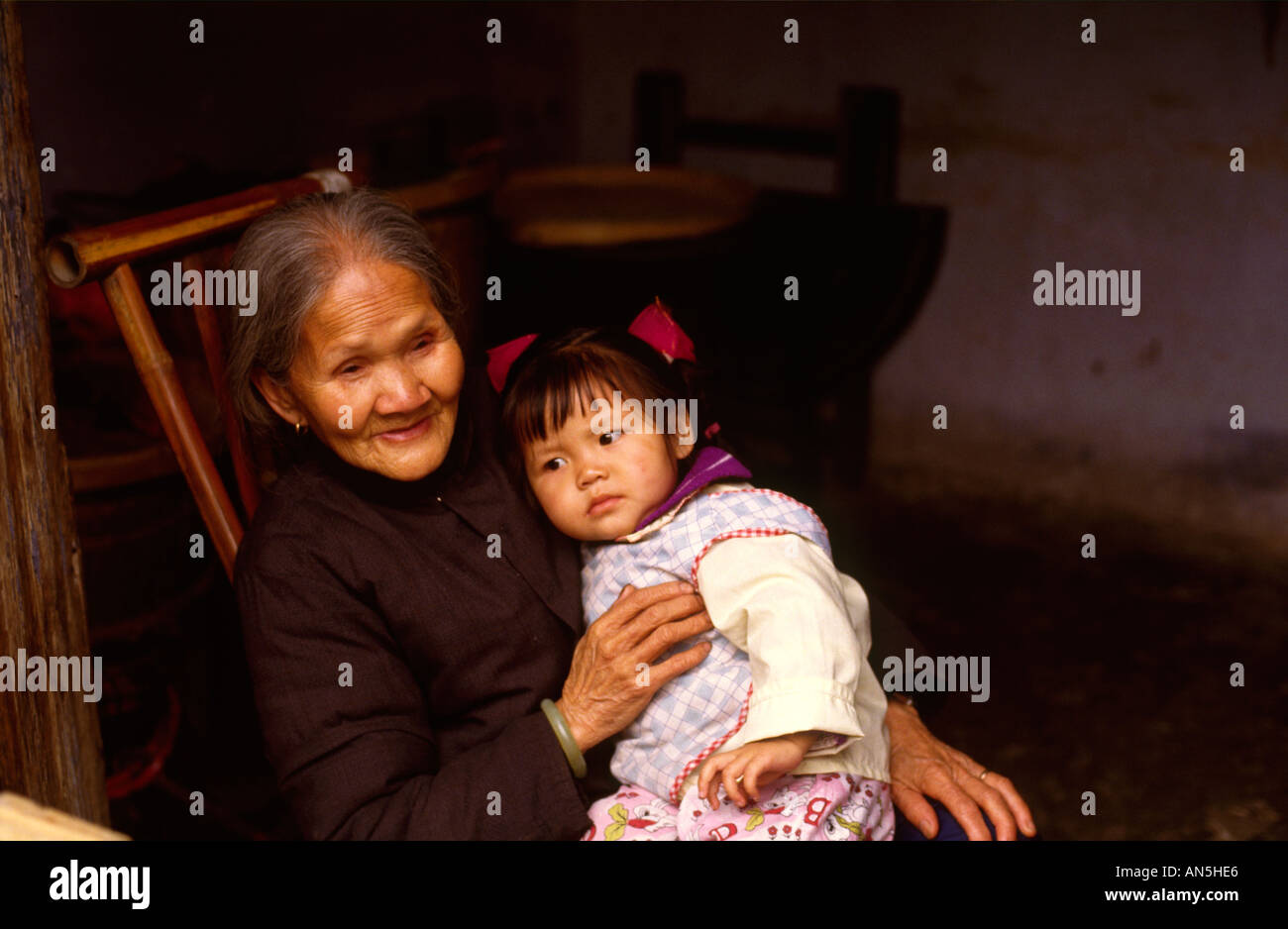 Ältere Frau mit jungen Mädchen in Yangshuo Dorf, Guangxi China traditionelles Kleid tragen. Stockfoto