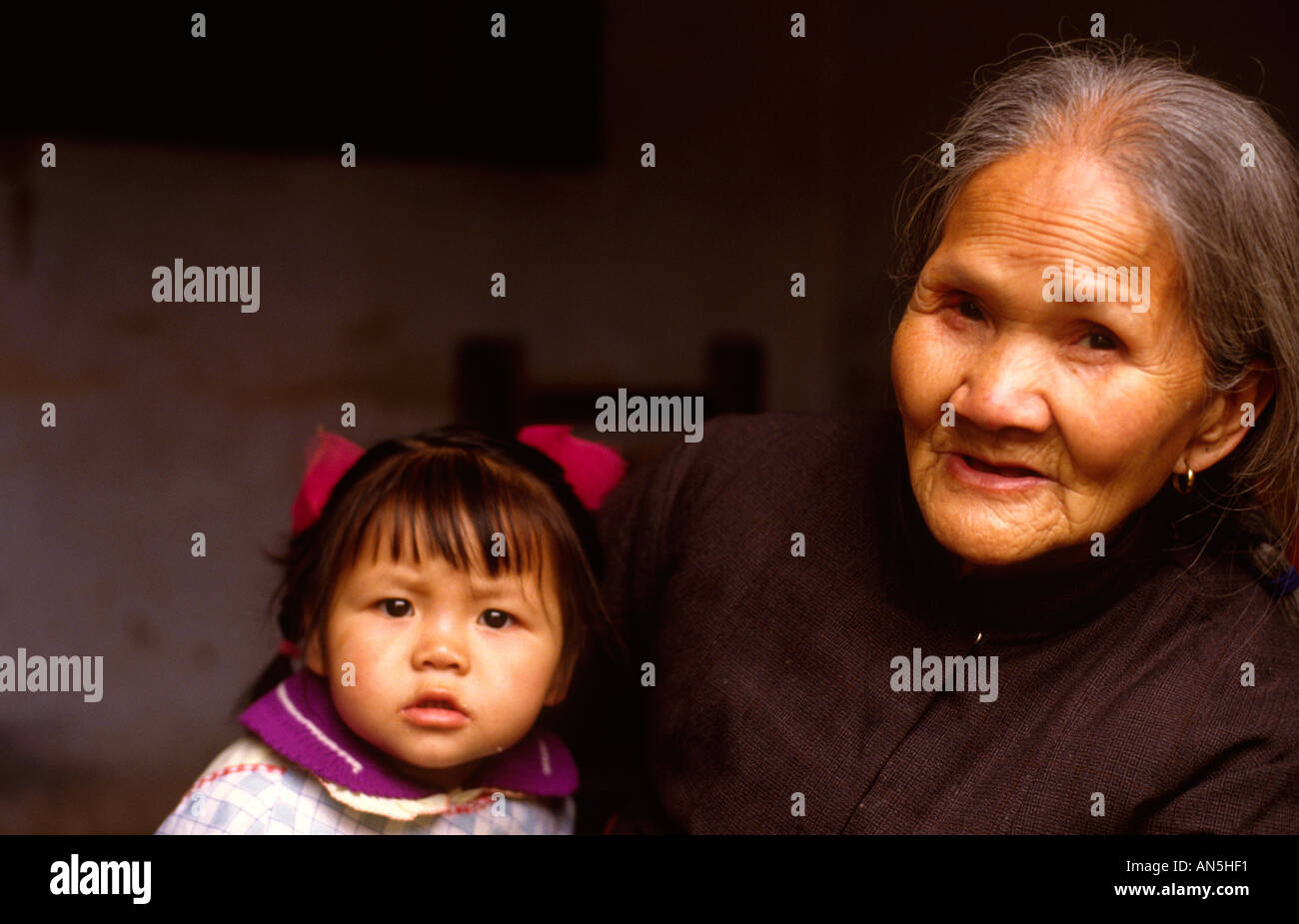 Ältere Frau mit jungen Mädchen in Yangshuo Dorf, Guangxi China tragen traditionelle Kleidung Stockfoto