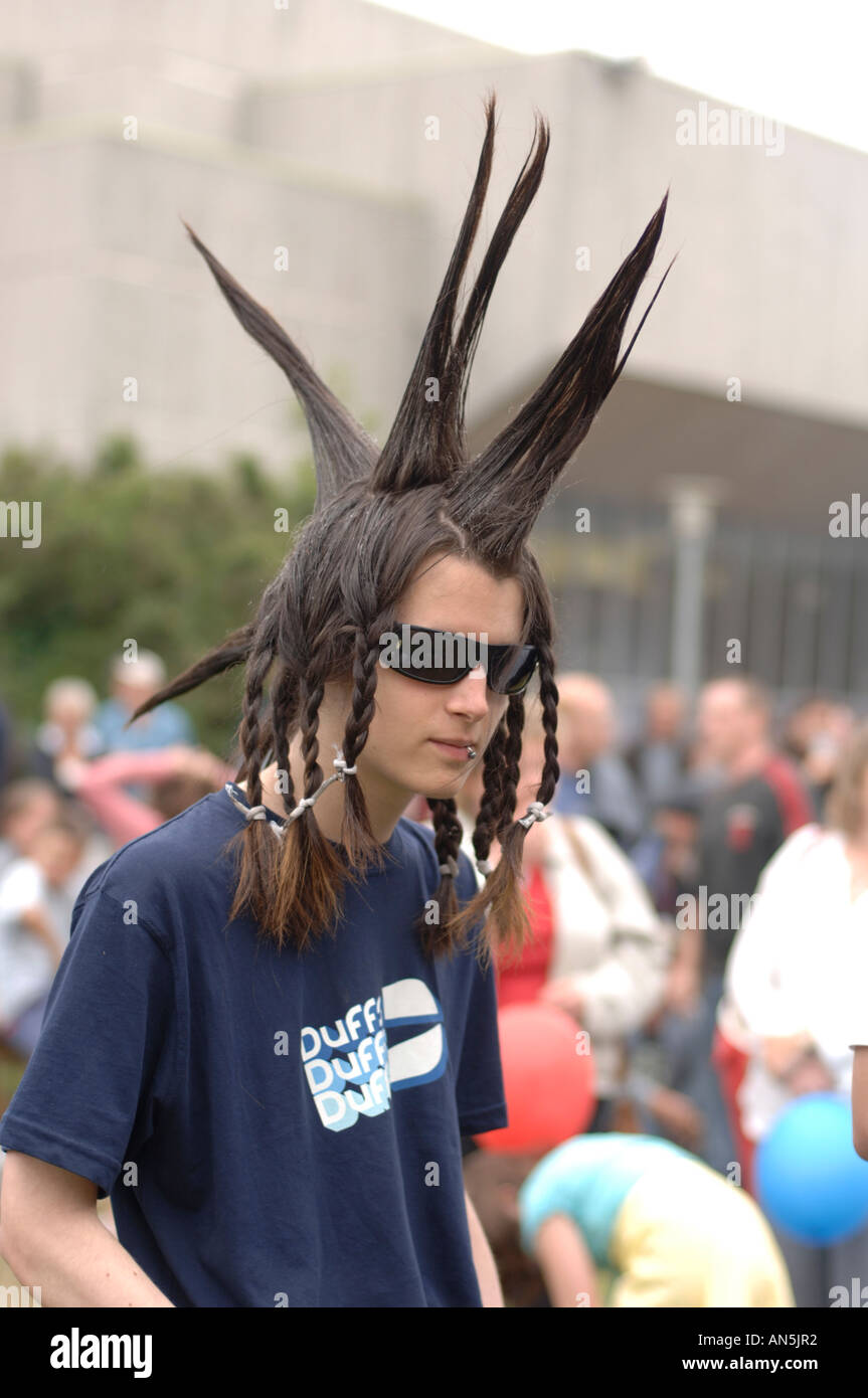 Junge Teenager Teen Punk-behaarte männliche Jugend, stachelig und geflochtene Haare, dunkle Sonnenbrille, Wales UK Stockfoto