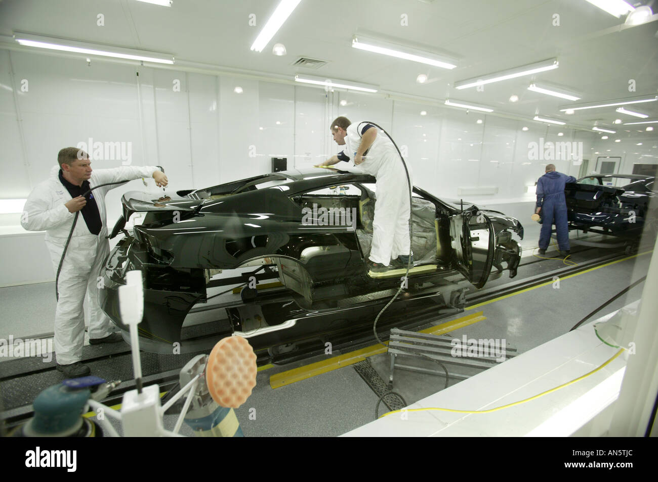 Arbeiter in der Fabrik von Aston Martin in Gaydon in Warwickshire UK sprühen und Polieren die Karosserie von einem DB9 Stockfoto