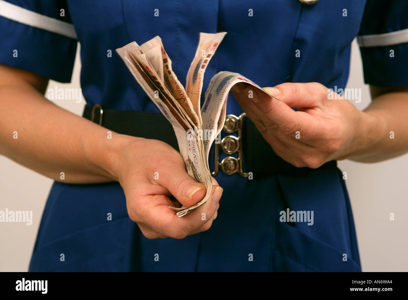 Krankenschwester in blauer Uniform, die ihr Geld zählen Stockfoto