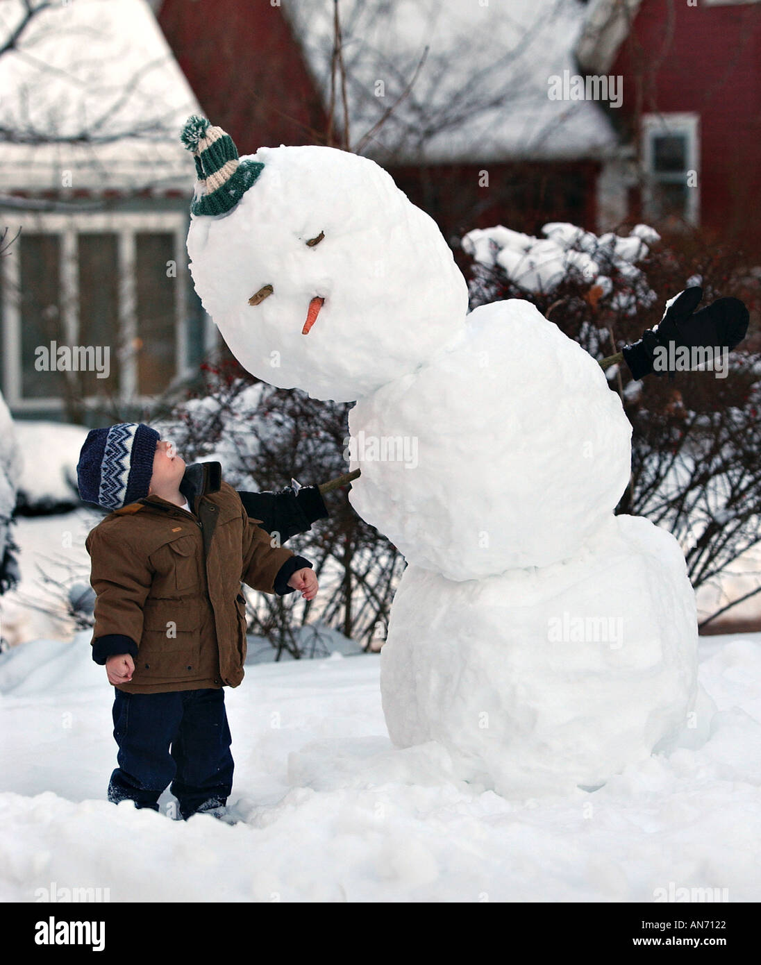 Kleiner Junge neben einem Schnee Mann Stockfoto